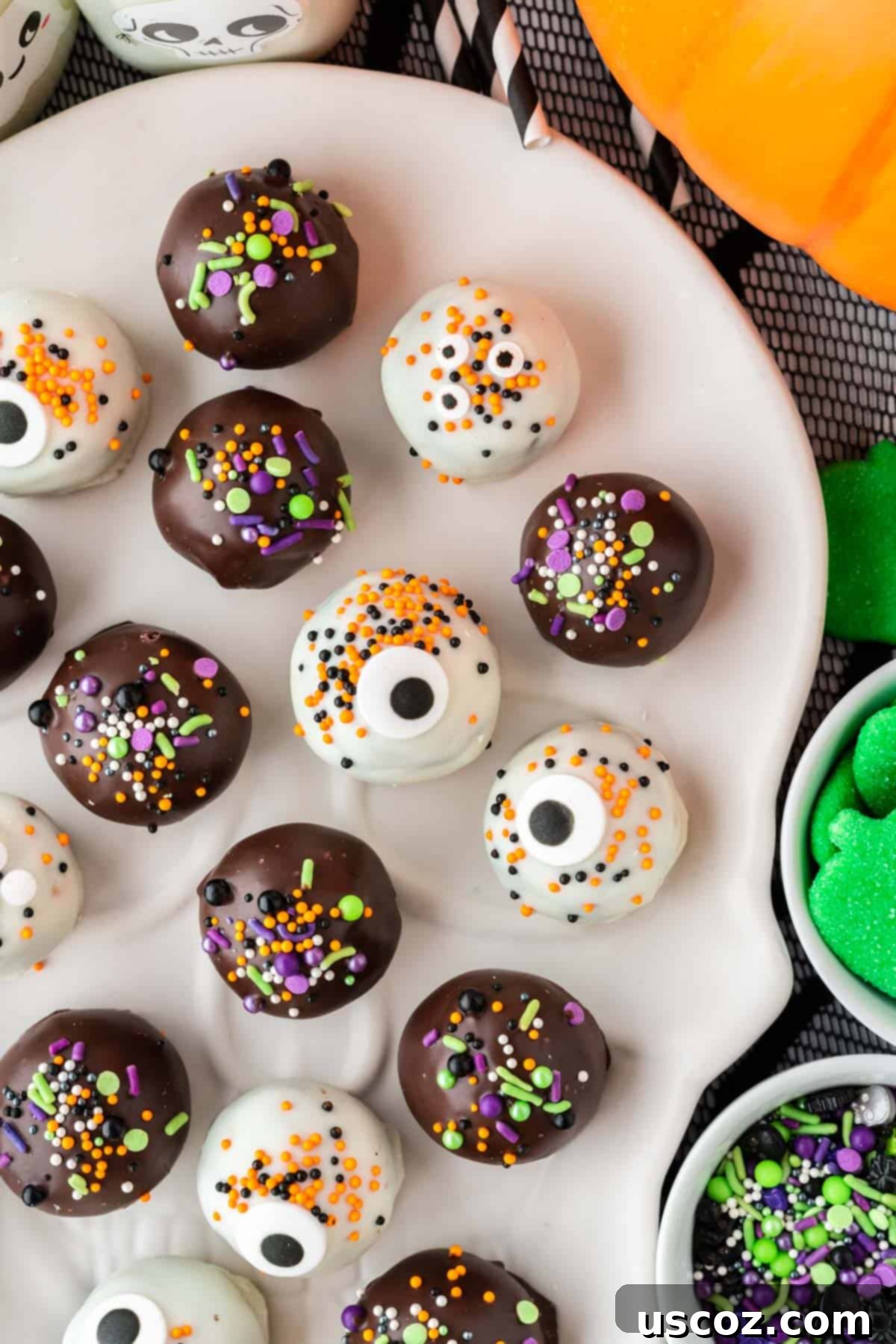 Spooky Oreo Truffles 2 halloween decorated oreo balls on a plate with purple and orange sprinkles