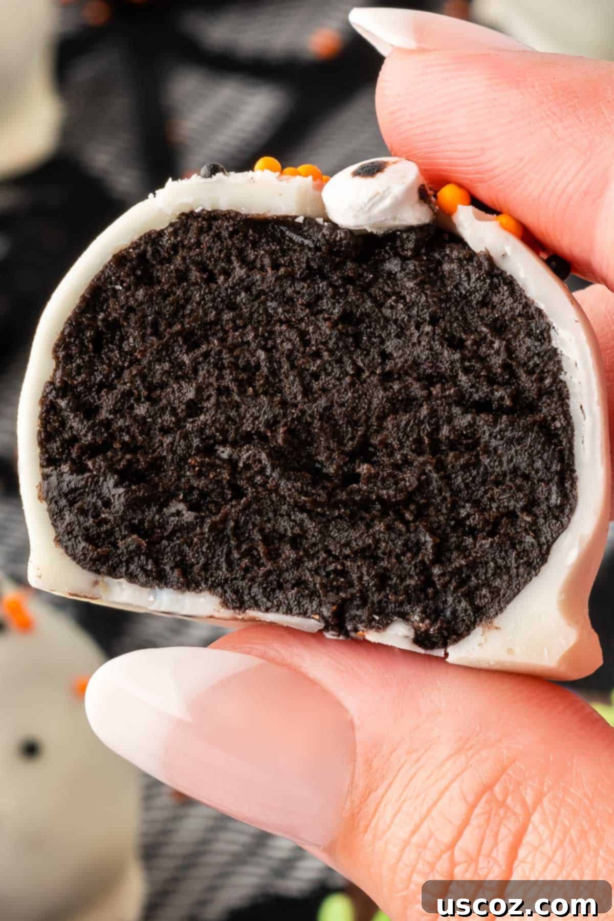 Spooky Oreo Truffles 20 A Halloween Oreo ball cut in half to show the rich, dark interior made of crushed Oreos and cream cheese