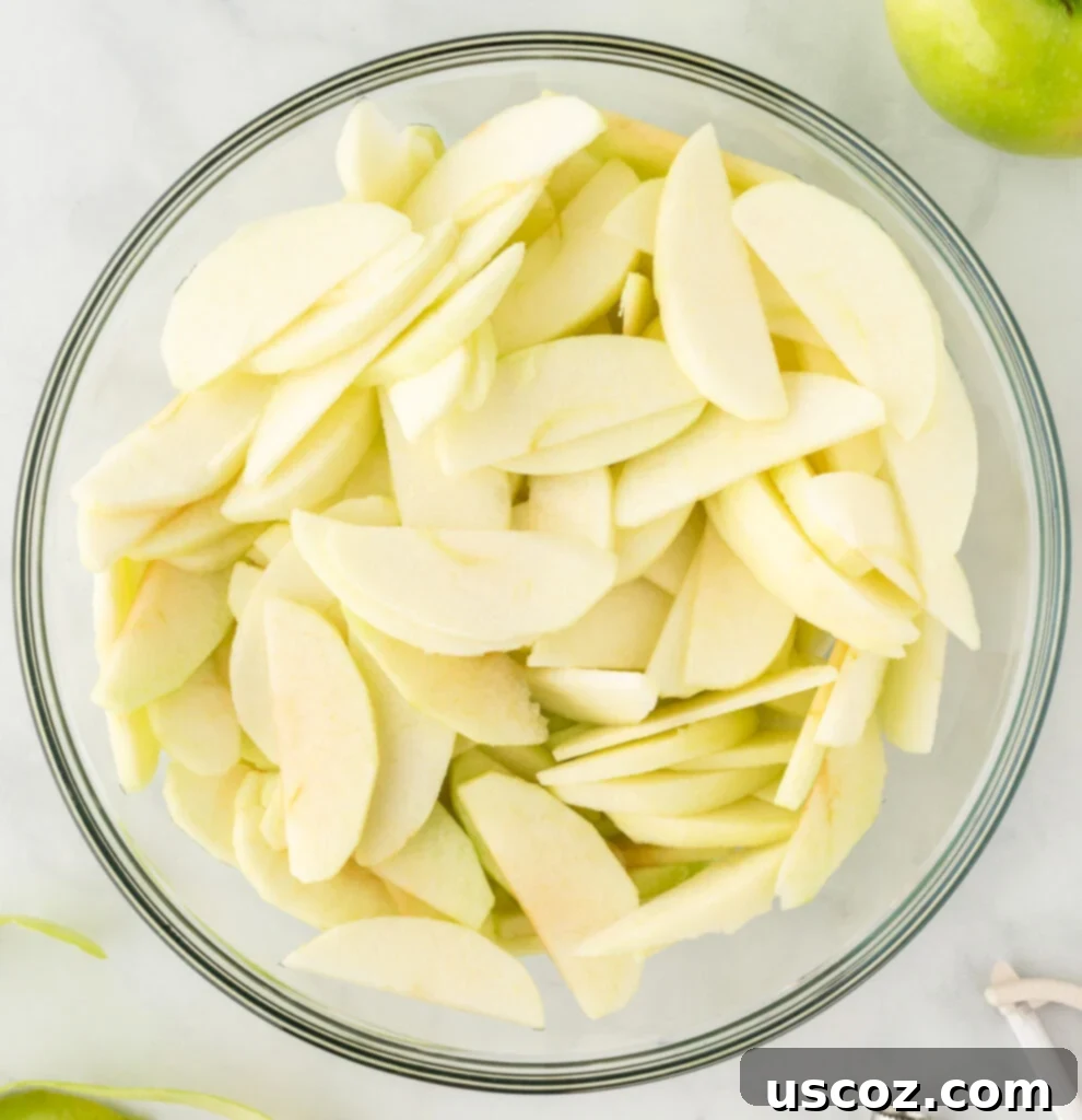 Effortless Apple Cobbler 4 Thinly sliced Granny Smith apples in a large mixing bowl, ready for seasoning.