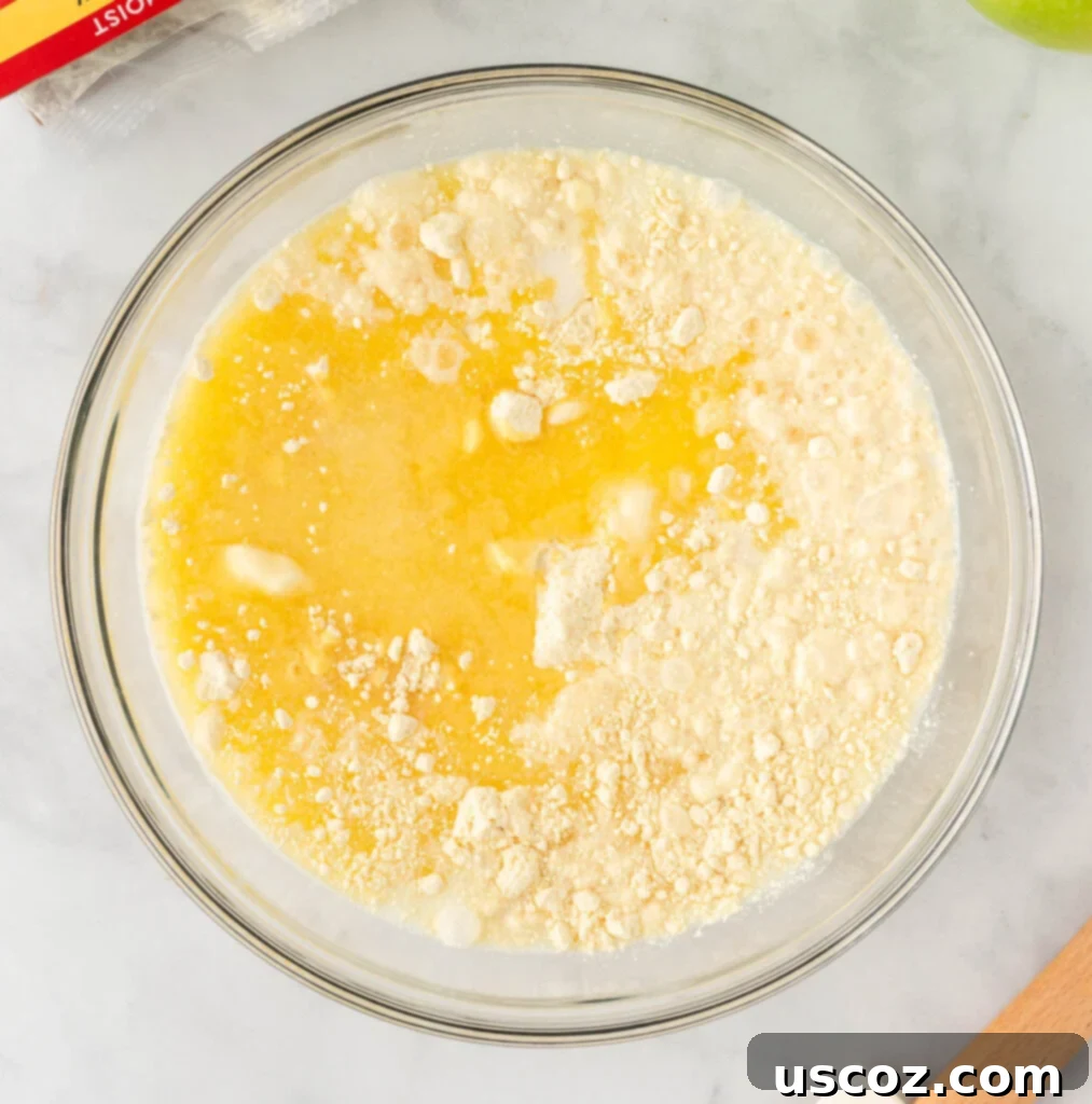Effortless Apple Cobbler 7 Yellow cake mix, milk, and melted butter in a bowl, before mixing to create the cobbler topping.