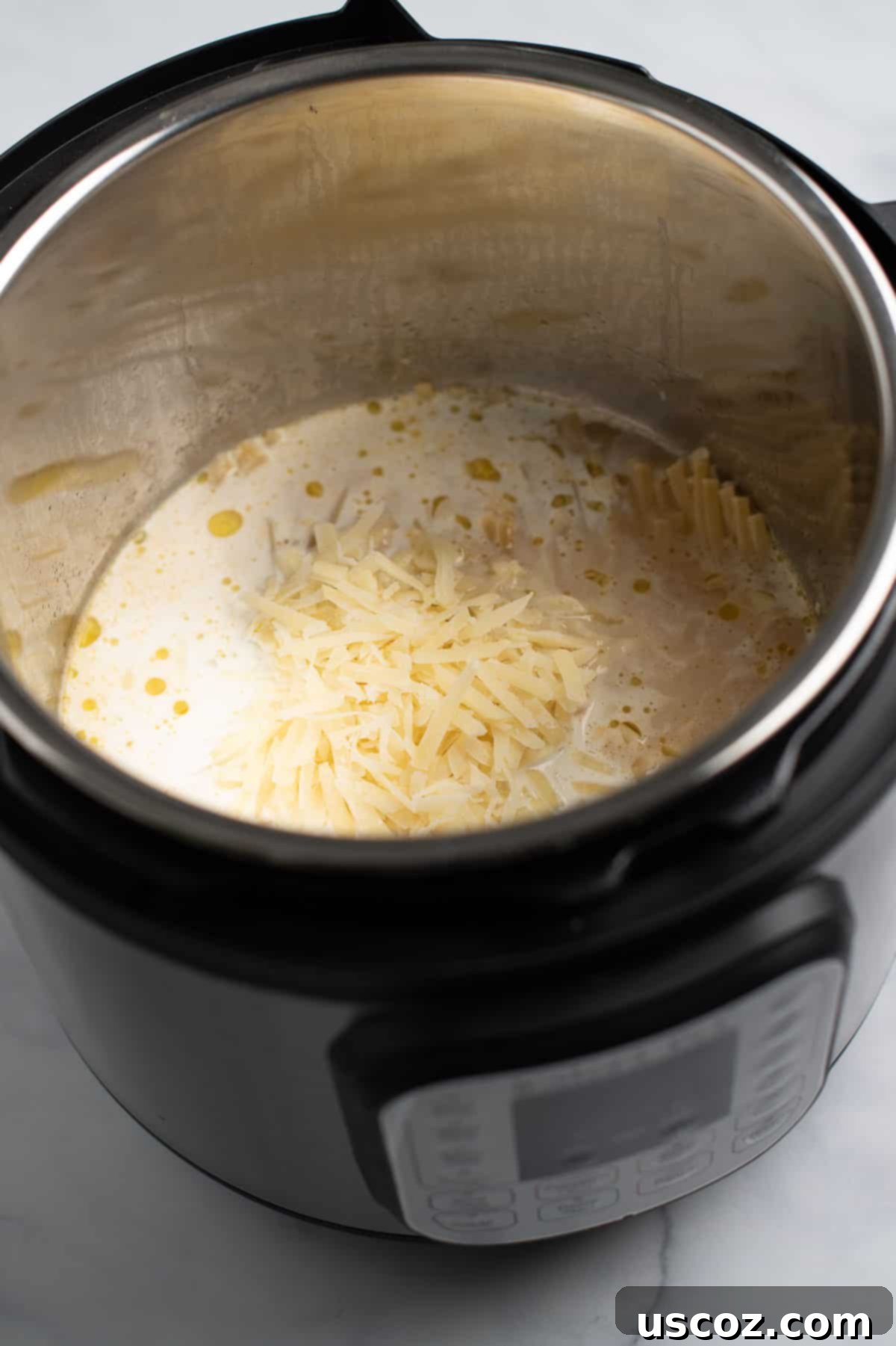 Quick and Creamy Instant Pot Pasta 6 Adding heavy cream and freshly grated parmesan cheese to the Instant Pot after pasta is cooked.