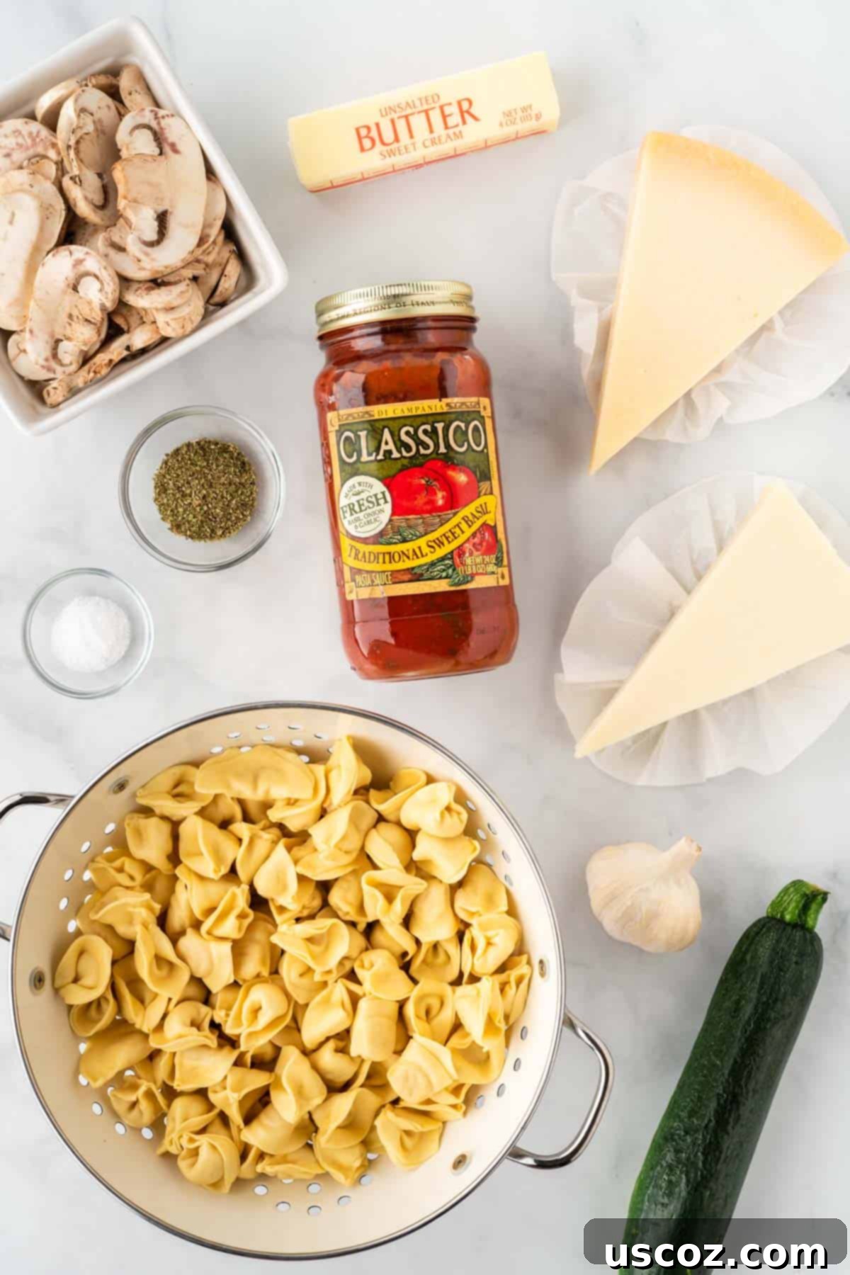Cheesy Tortellini Bake 3 ingredients needed to make cheesy baked tortellini, including tortellini, sauce, mushrooms, zucchini, garlic, butter, and cheese