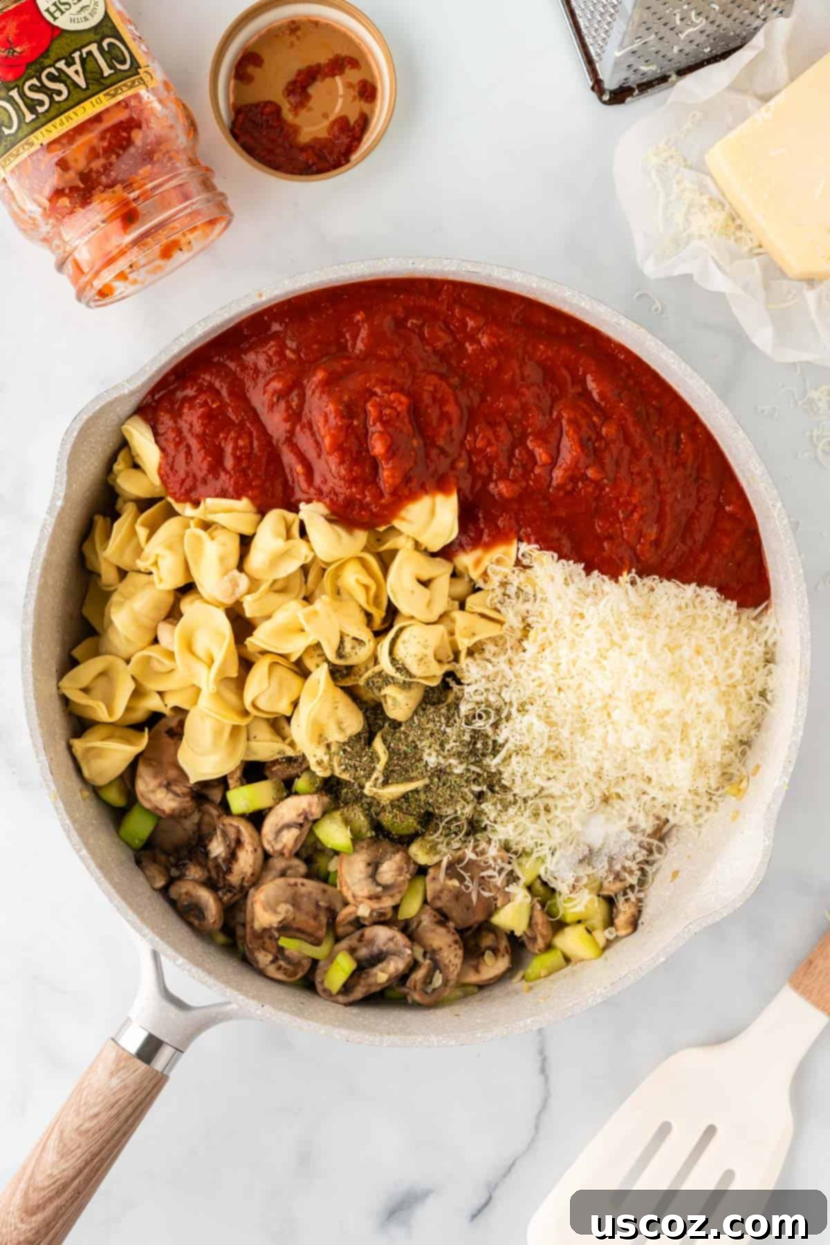 Cheesy Tortellini Bake 6 adding sauce, Parmesan cheese, Italian seasoning, and tortellini to the skillet with cooked vegetables