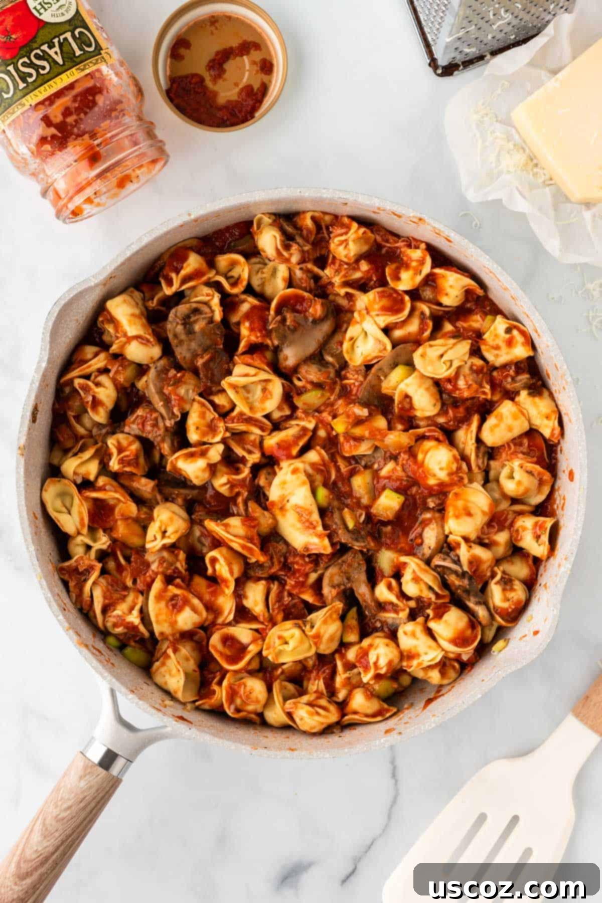 Cheesy Tortellini Bake 7 skillet full of combined veggie and tortellini mixture, ready for baking