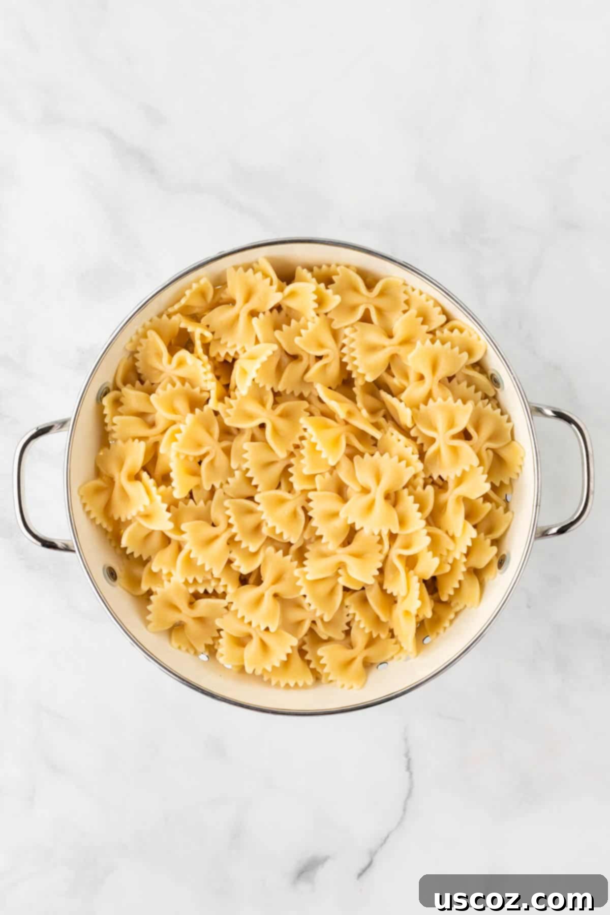 Crispy Air Fryer Pasta Chips 6 Cooked bowtie pasta draining in a colander after being removed from boiling water.