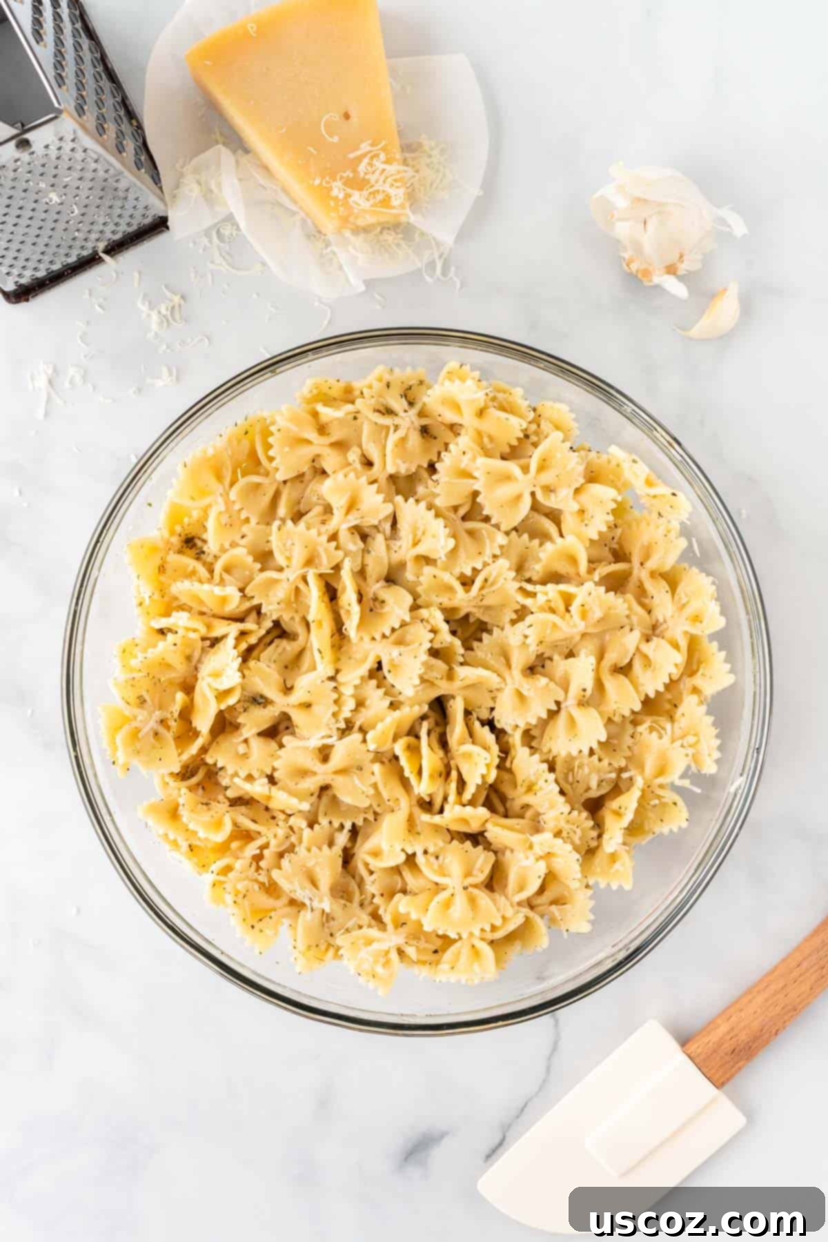 Crispy Air Fryer Pasta Chips 8 Cooked bowtie pasta thoroughly mixed with olive oil, minced garlic, Italian seasoning, and parmesan cheese, ready for air frying.