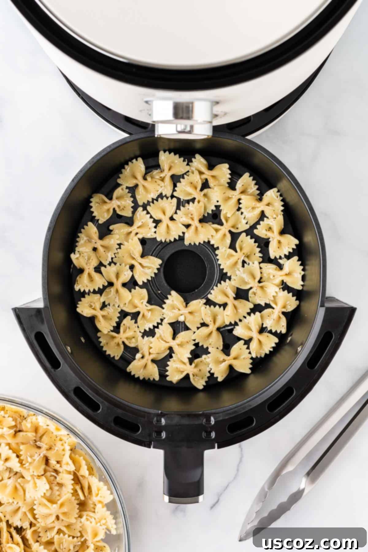Crispy Air Fryer Pasta Chips 9 Seasoned bowtie pasta arranged in a single layer in the air fryer basket, ready for cooking.