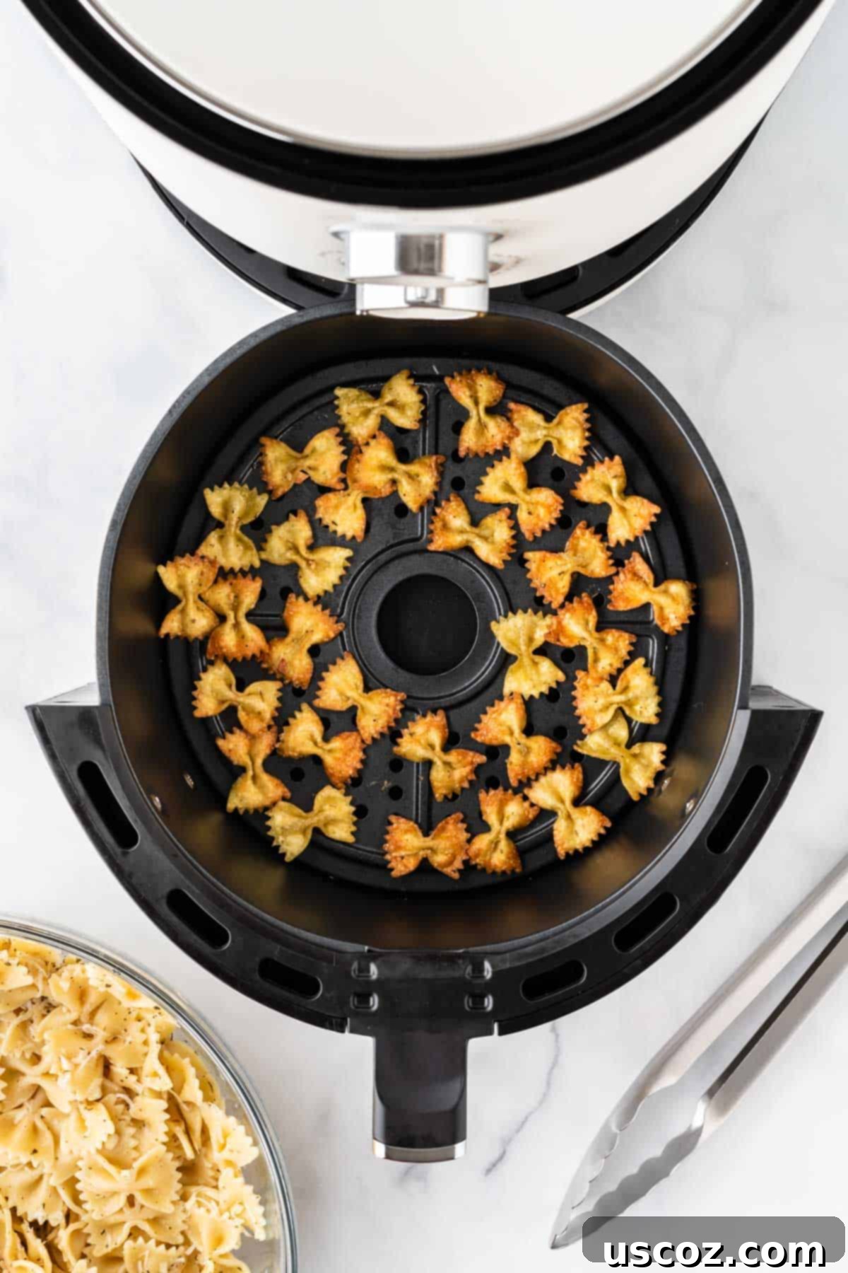 Crispy Air Fryer Pasta Chips 10 A batch of air fryer pasta chips cooking in the basket, showing an even layer of pasta turning golden brown.