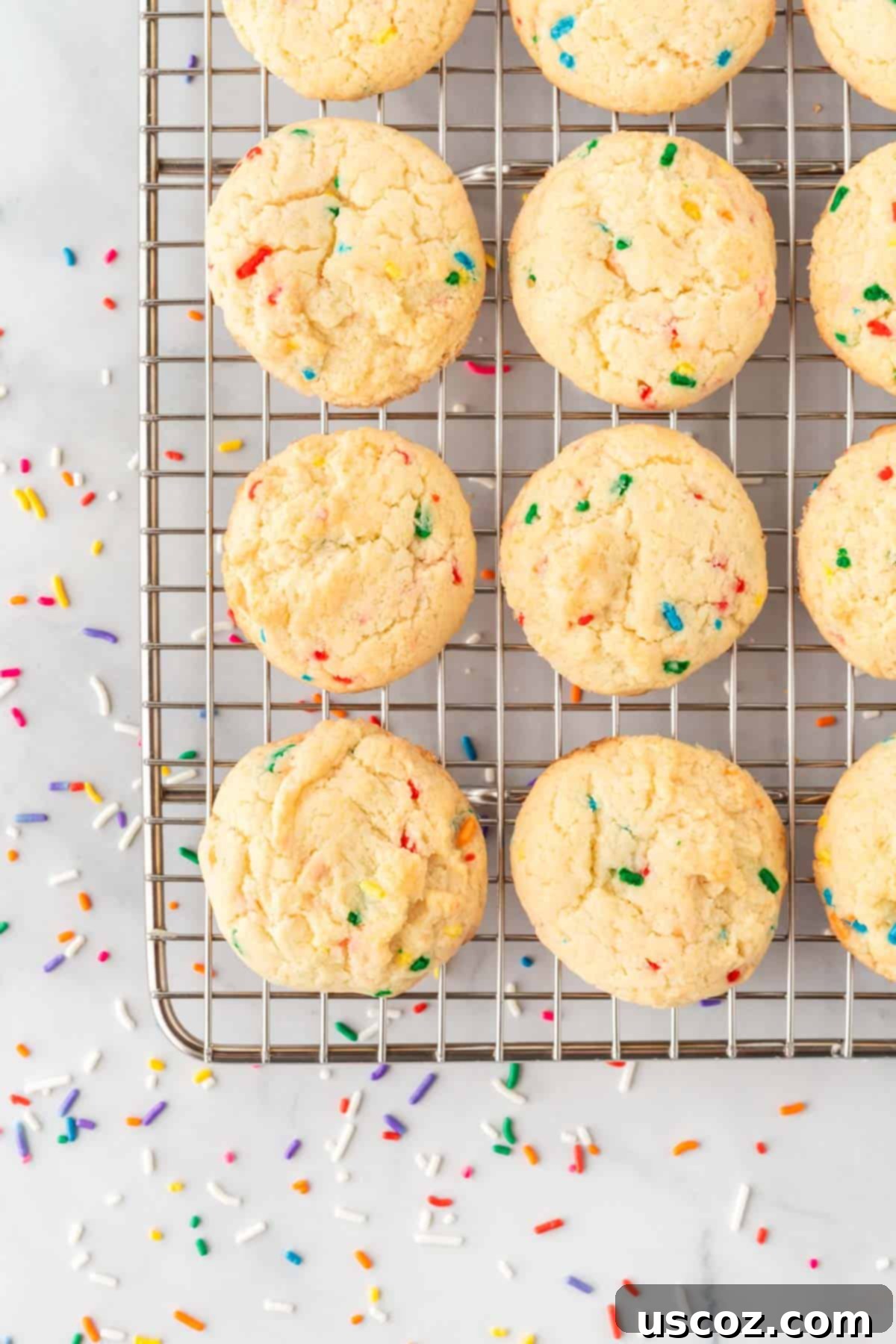 Effortless Rainbow Cake Cookies 9 Freshly baked funfetti cookies cooling on a wire rack, steam gently rising, ready to be devoured.