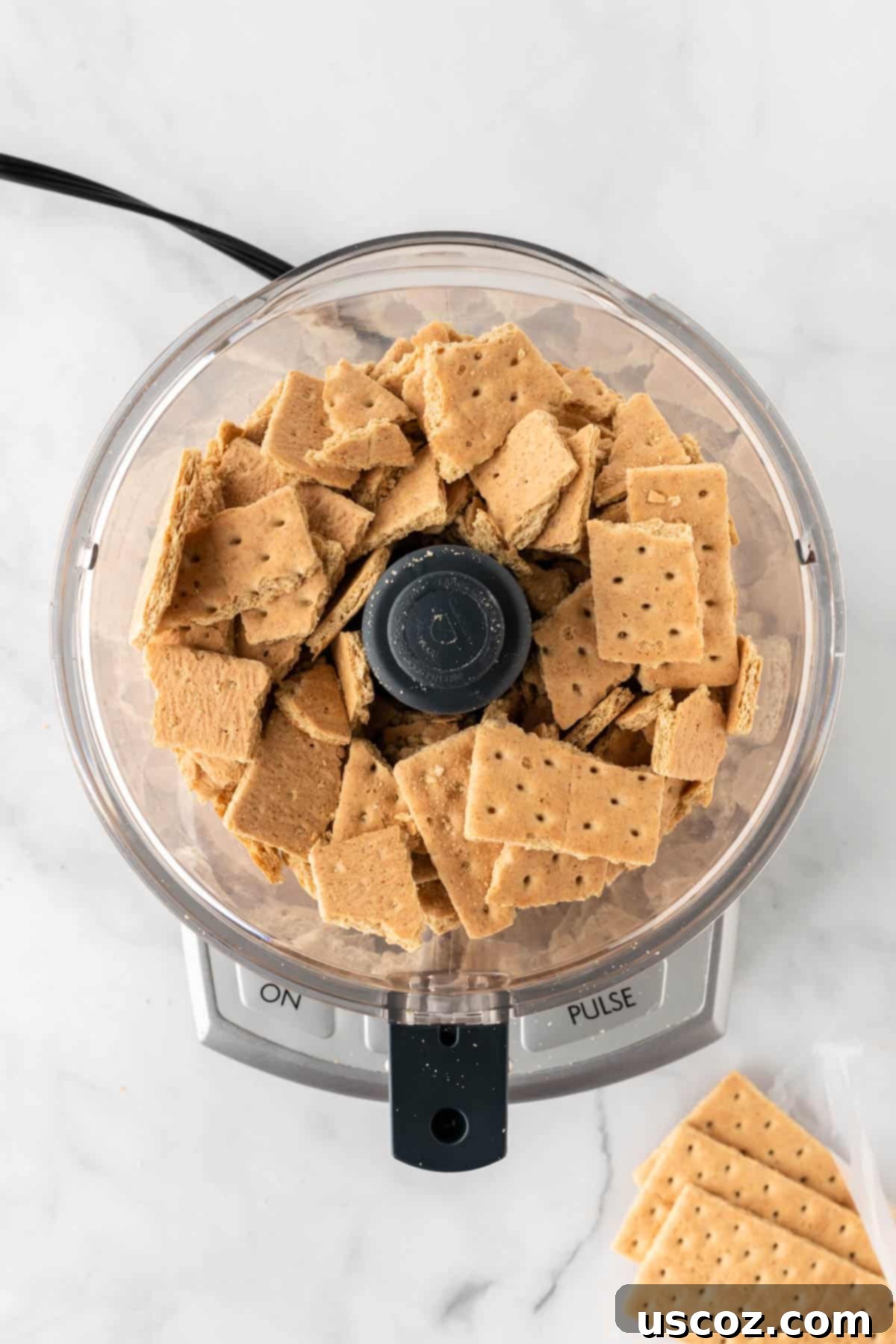Creamy No-Bake Cheesecake Bliss 5 graham crackers in a food processor, ready to be crushed