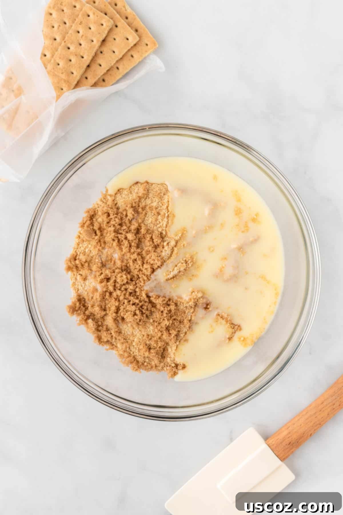 Creamy No-Bake Cheesecake Bliss 7 melted butter being mixed into crushed graham crackers in a bowl