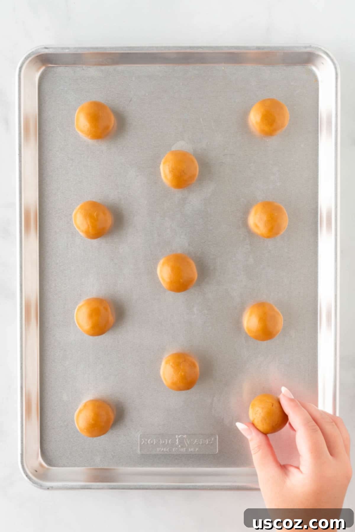 Easy Cake Mix Peanut Butter Cookies 10 Evenly spaced, rolled balls of peanut butter cookie dough on a baking sheet, ready for the fork press.