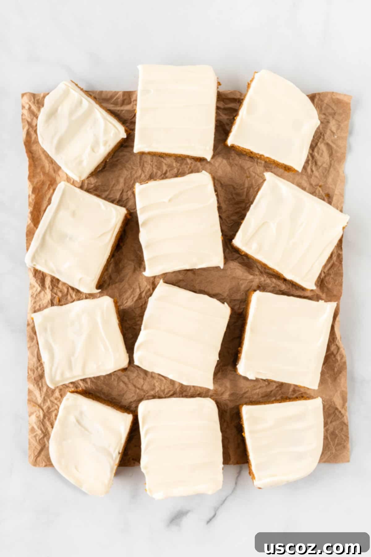 Easy Cake Mix Pumpkin Bars 11 cake mix pumpkin bars cut into 12 perfect squares, showcasing the moist interior and thick frosting