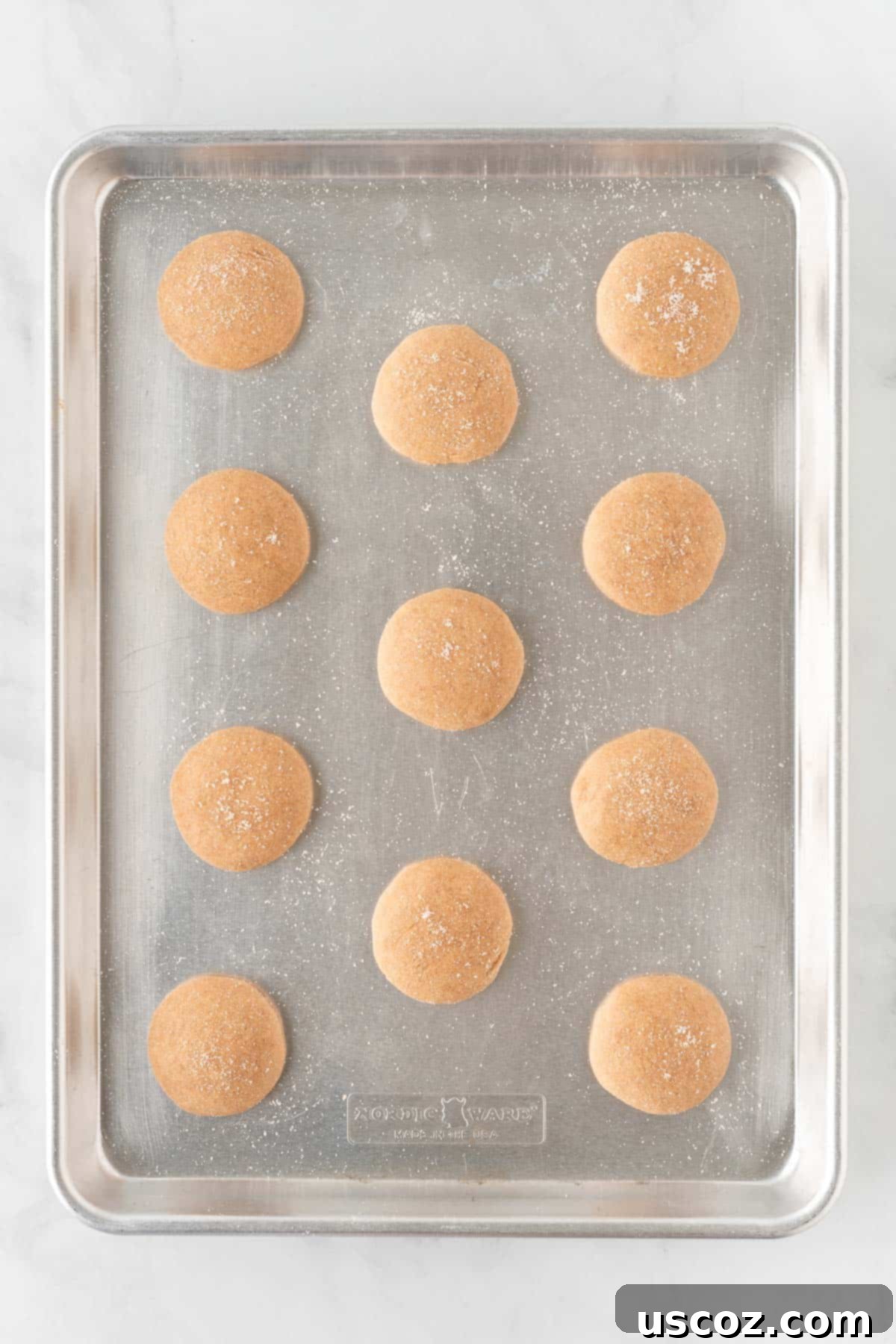 Quick Cake Mix Spice Cookies 9 Sugar-coated spice cookie dough balls perfectly spaced on a baking sheet, ready for the oven.
