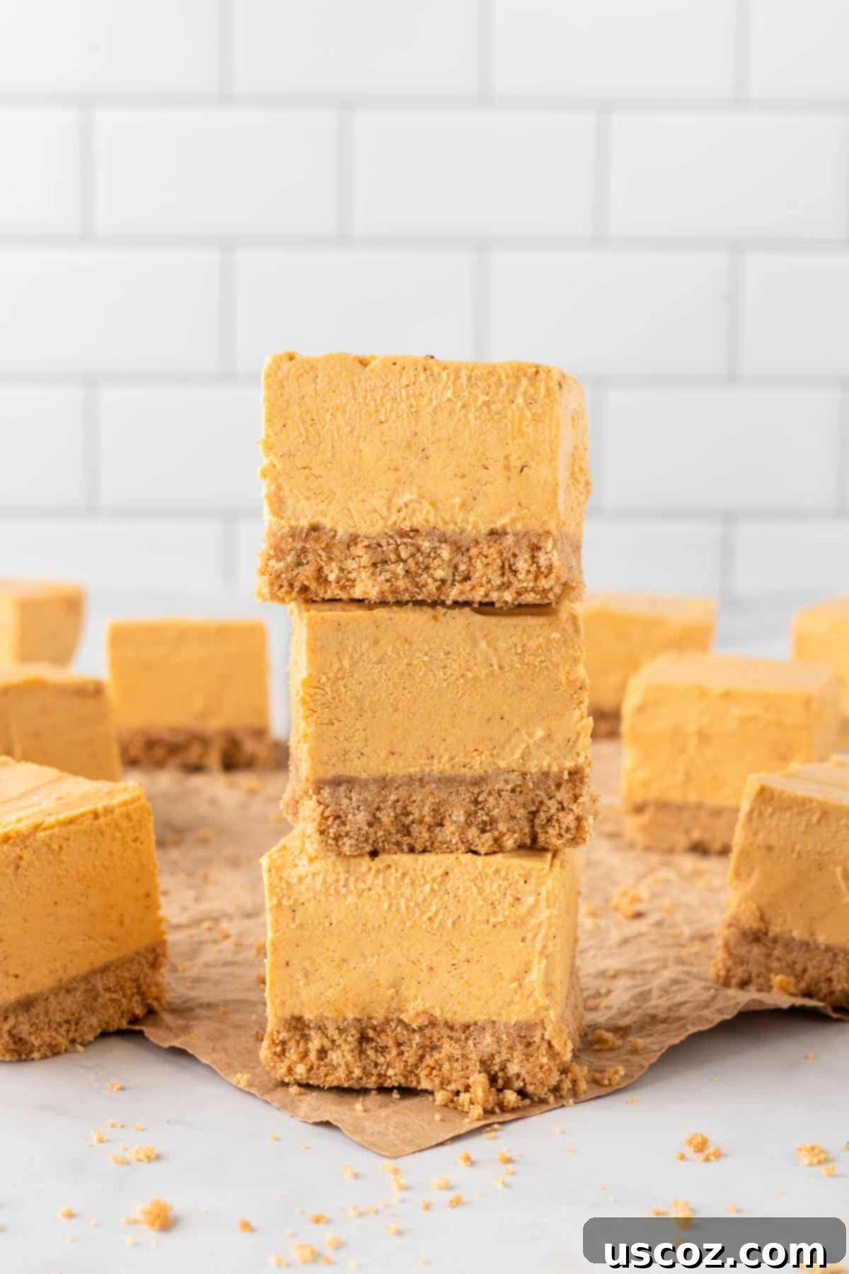 Easy No-Bake Pumpkin Cheesecake Bars 17 stack of no bake pumpkin cheesecake bars, showing the thick creamy filling and crunchy crust