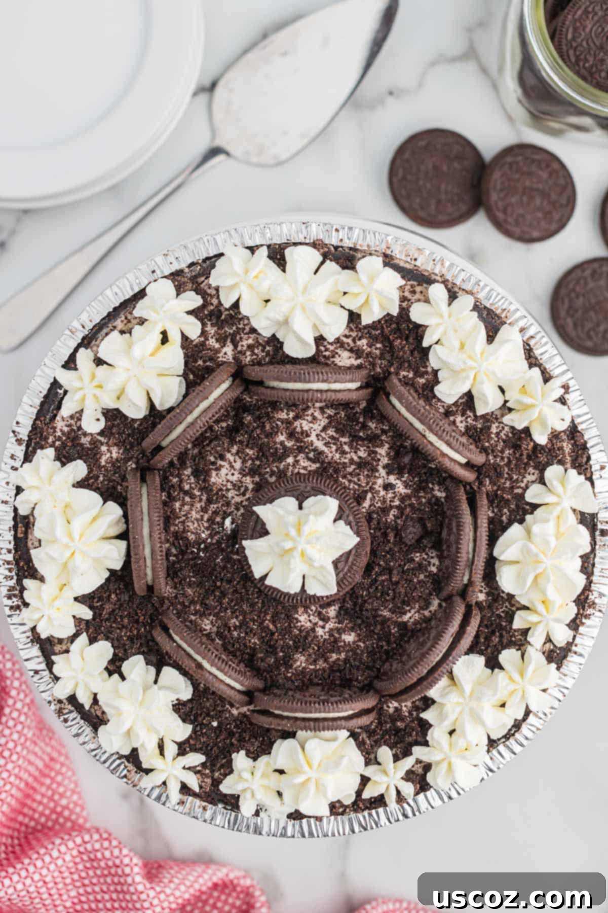 Oreo Bliss Pie 10 A perfectly decorated No-Bake Oreo Pie, garnished with dollops of whipped cream and whole Oreo cookies, ready for slicing.