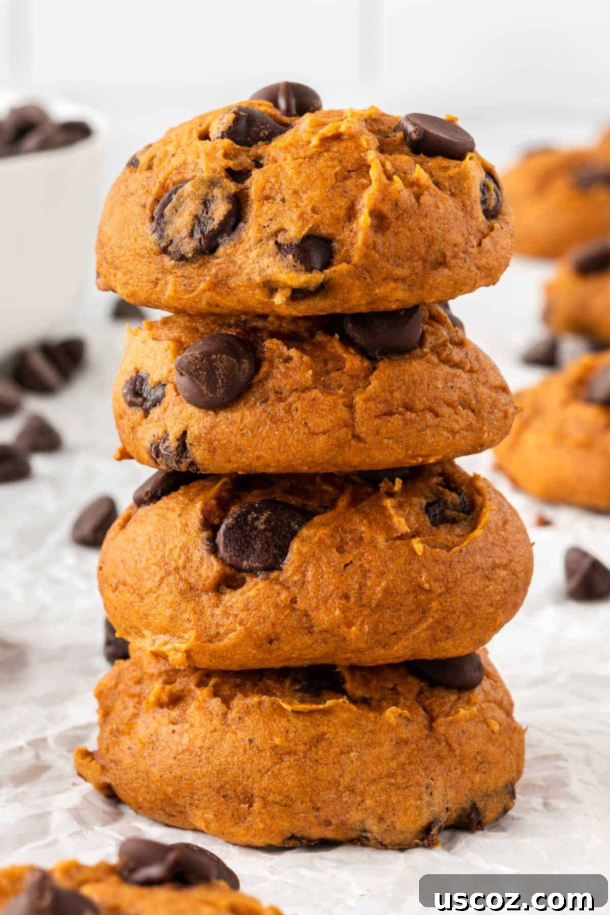 Easy Pumpkin Cake Mix Cookies 3 chocolate chip pumpkin cookies stacked on a plate