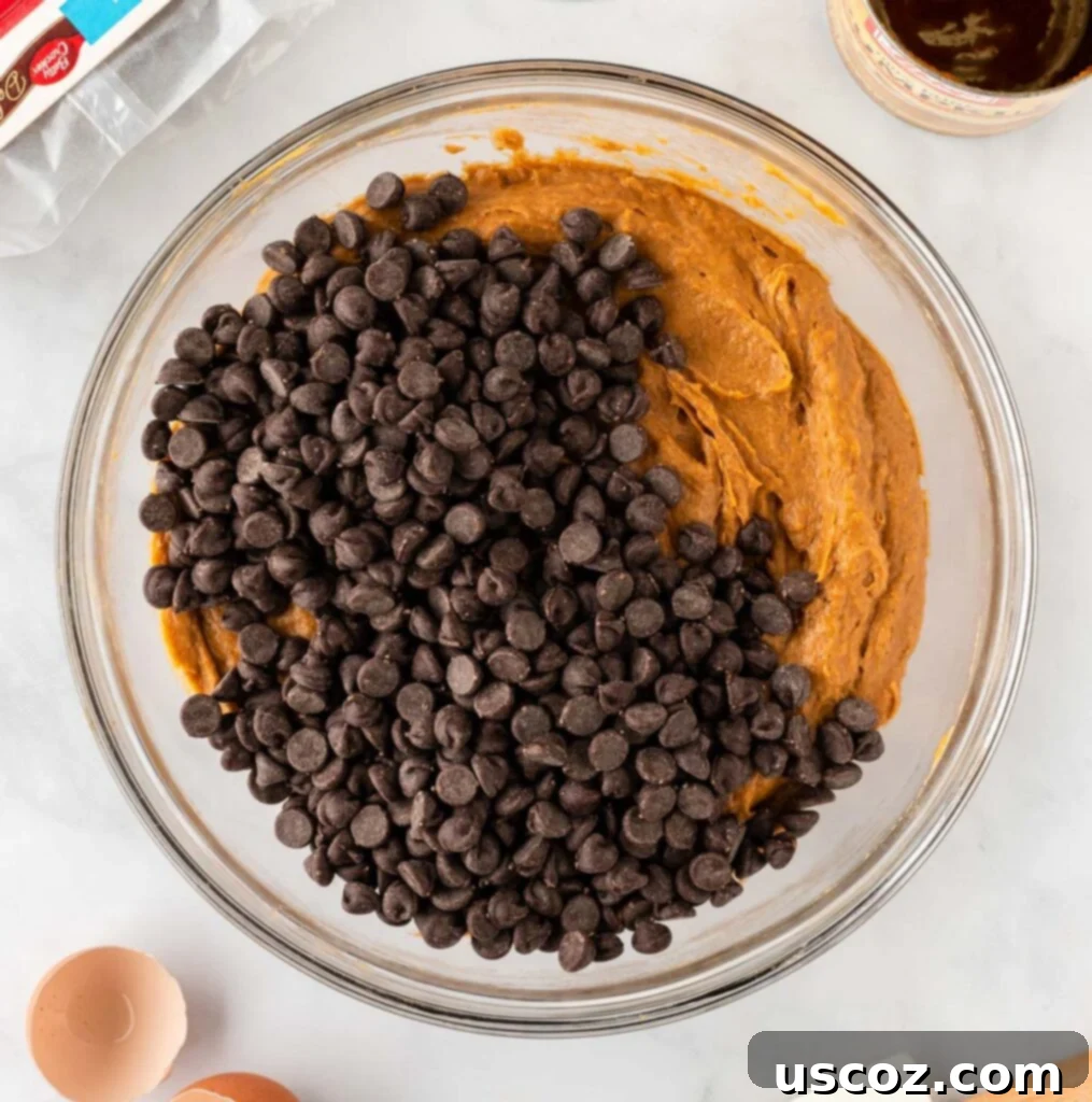 Easy Pumpkin Cake Mix Cookies 9 adding chocolate chips to the pumpkin cookie batter