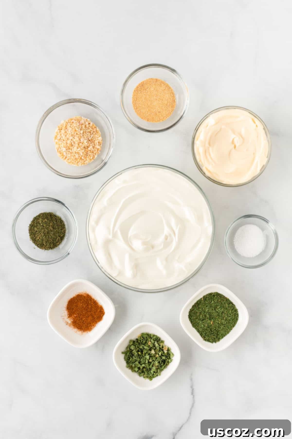 Garden Fresh Dip 4 A collection of ingredients laid out on a clean surface, including a tub of sour cream, a jar of mayonnaise, and small containers of various dried spices like garlic powder, minced onion, dill, chives, paprika, and parsley, ready to be combined for the veggie dip.