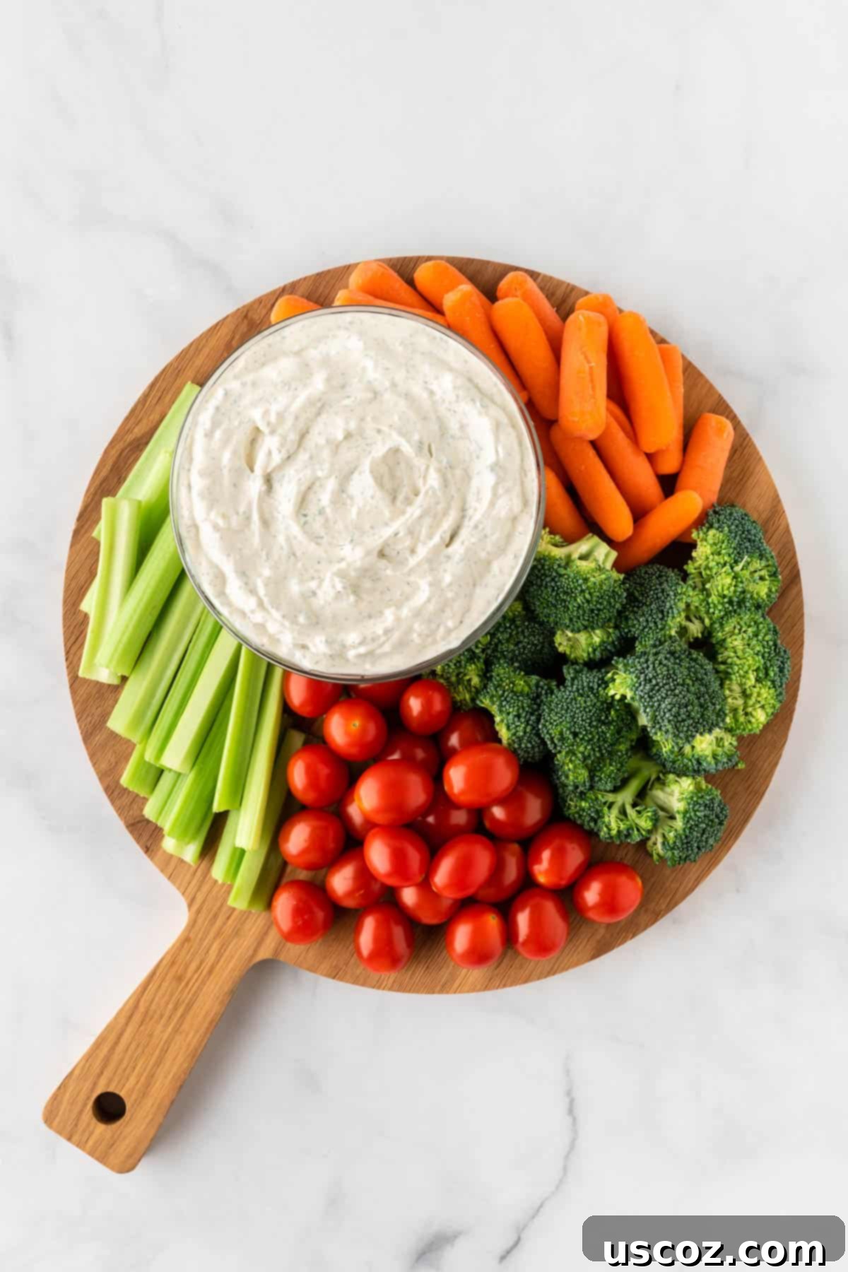 Garden Fresh Dip 8 A wooden cutting board beautifully arranged with an assortment of freshly cut vegetables, including bell peppers, cucumbers, broccoli, and carrots, alongside a small bowl of creamy homemade veggie dip, emphasizing fresh ingredients.