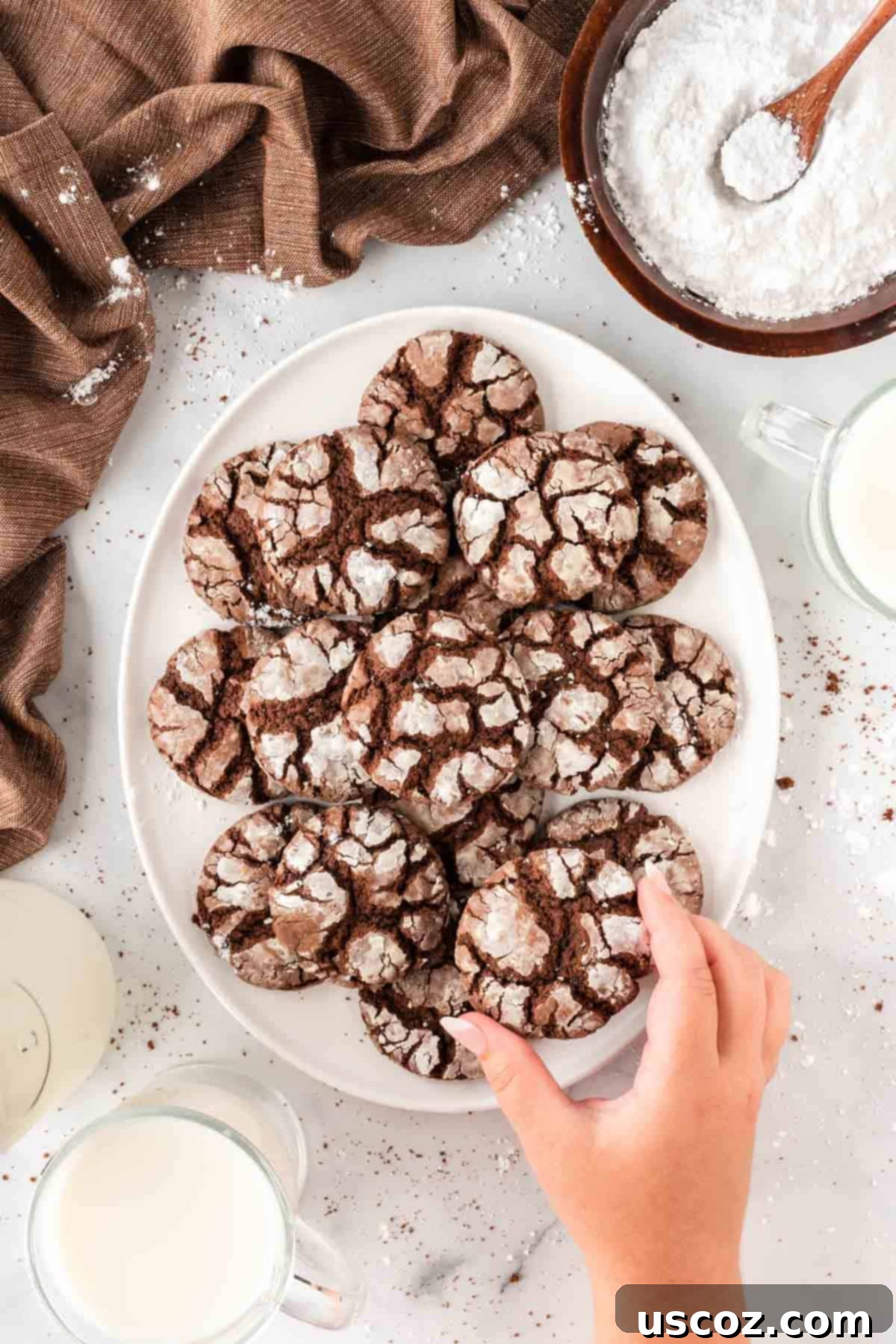 Irresistible Cake Mix Crinkles 15 taking a crinkle cookie from a platter