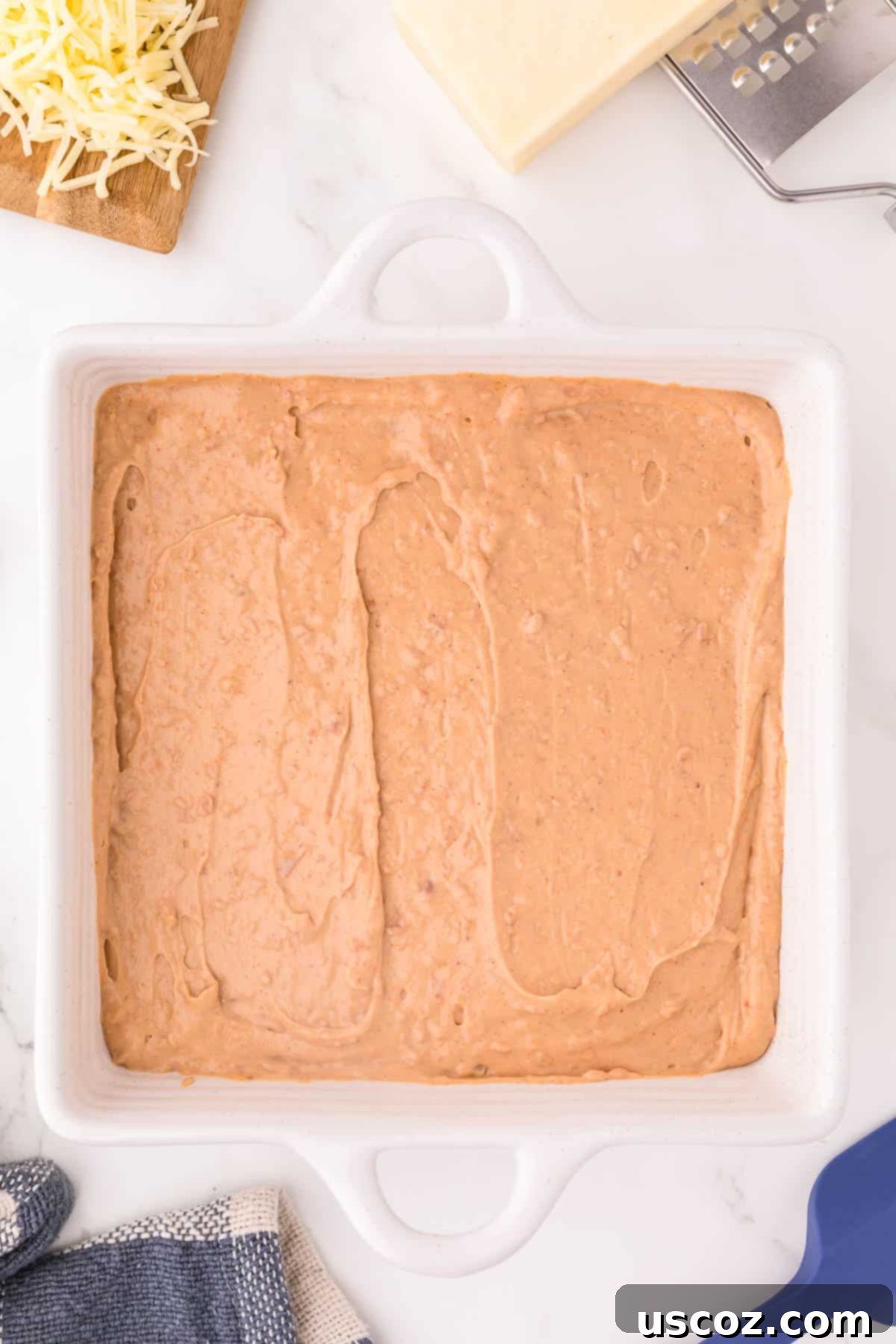 Rich Cream Cheese Bean Dip 5 The bean dip mixture smoothly spread out in a greased baking dish, ready for cheese