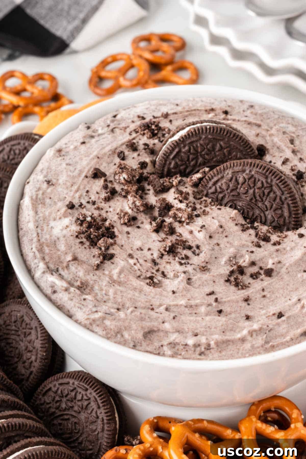 Creamy Oreo Dip 11 Oreo dip in a bowl on a platter surrounded by various dippers like Nilla wafers, Oreos, strawberries, and pretzels