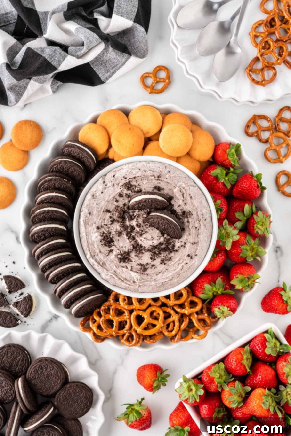 Creamy Oreo Dip 13 A beautiful platter with a bowl of Oreo dip, surrounded by fresh strawberries, Nilla Wafers, pretzels, and whole Oreos for dipping, showcasing a festive party spread.
