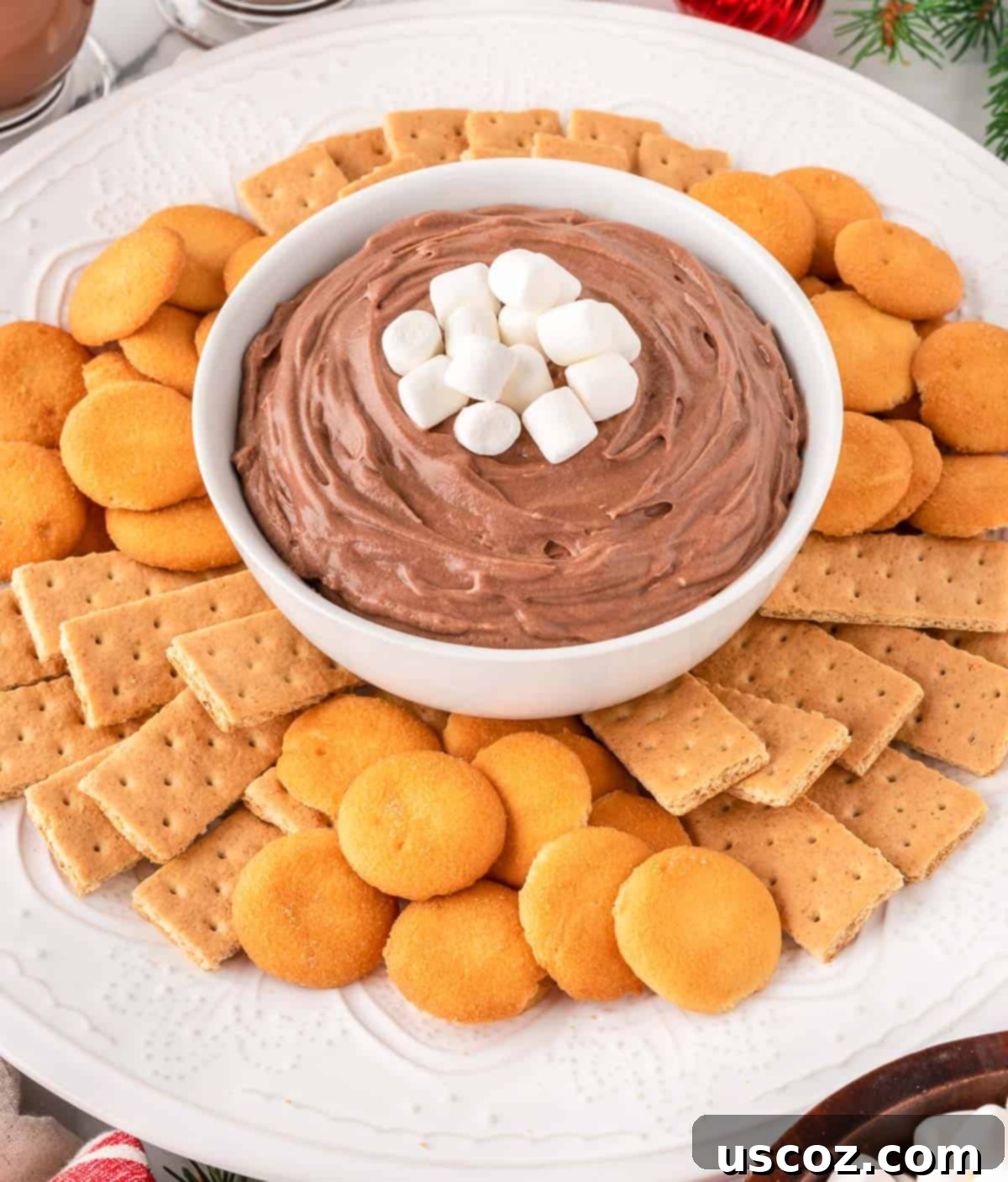 Cozy Chocolate Dip 3 A festive platter showcasing creamy hot chocolate dip surrounded by a delicious assortment of Nilla Wafers and graham crackers.