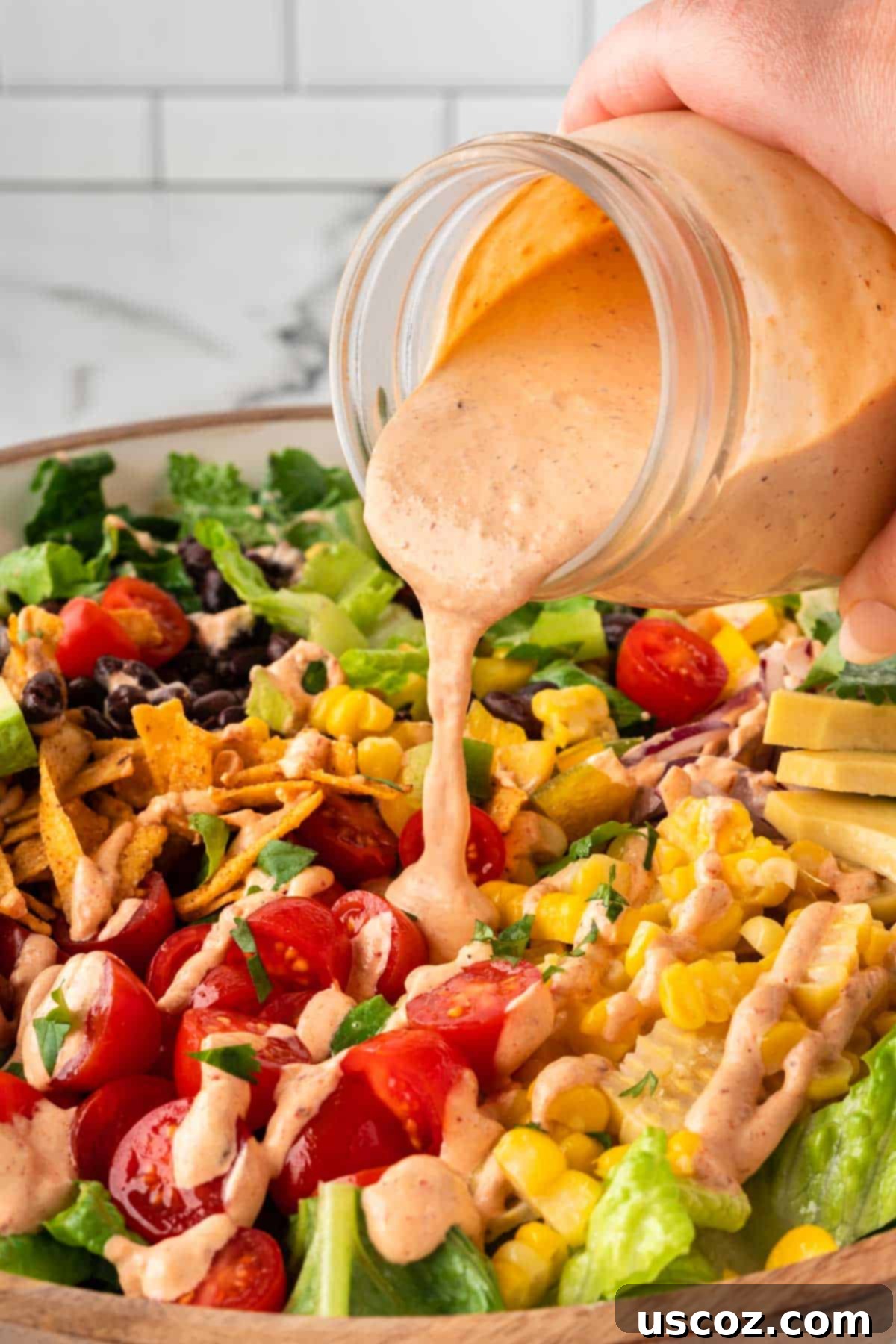 Southwest Fiesta Salad 9 pouring southwest salad dressing over a salad