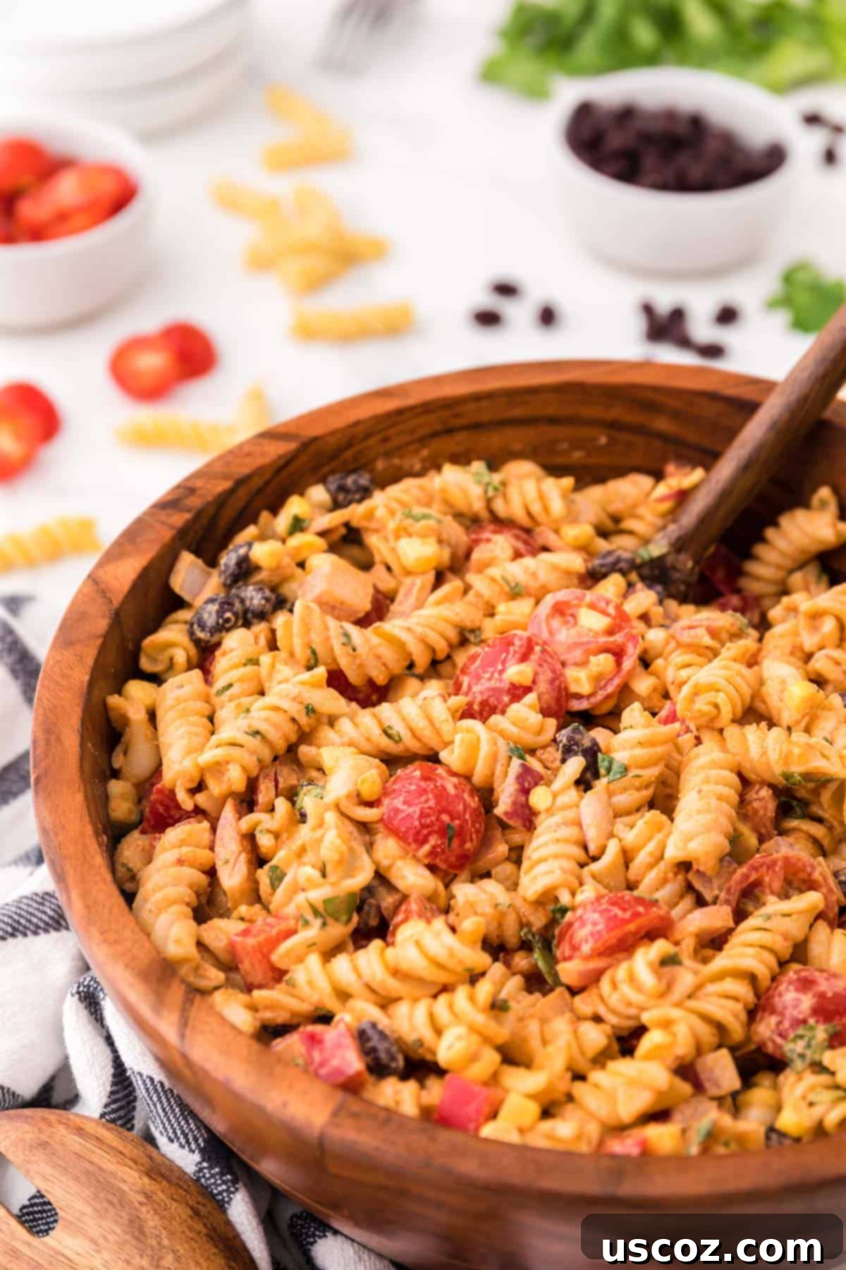 Zesty Southwest Pasta Delight 2 A large brown serving bowl overflowing with colorful Southwest Pasta Salad, featuring rotini pasta, corn, black beans, tomatoes, and a creamy dressing.