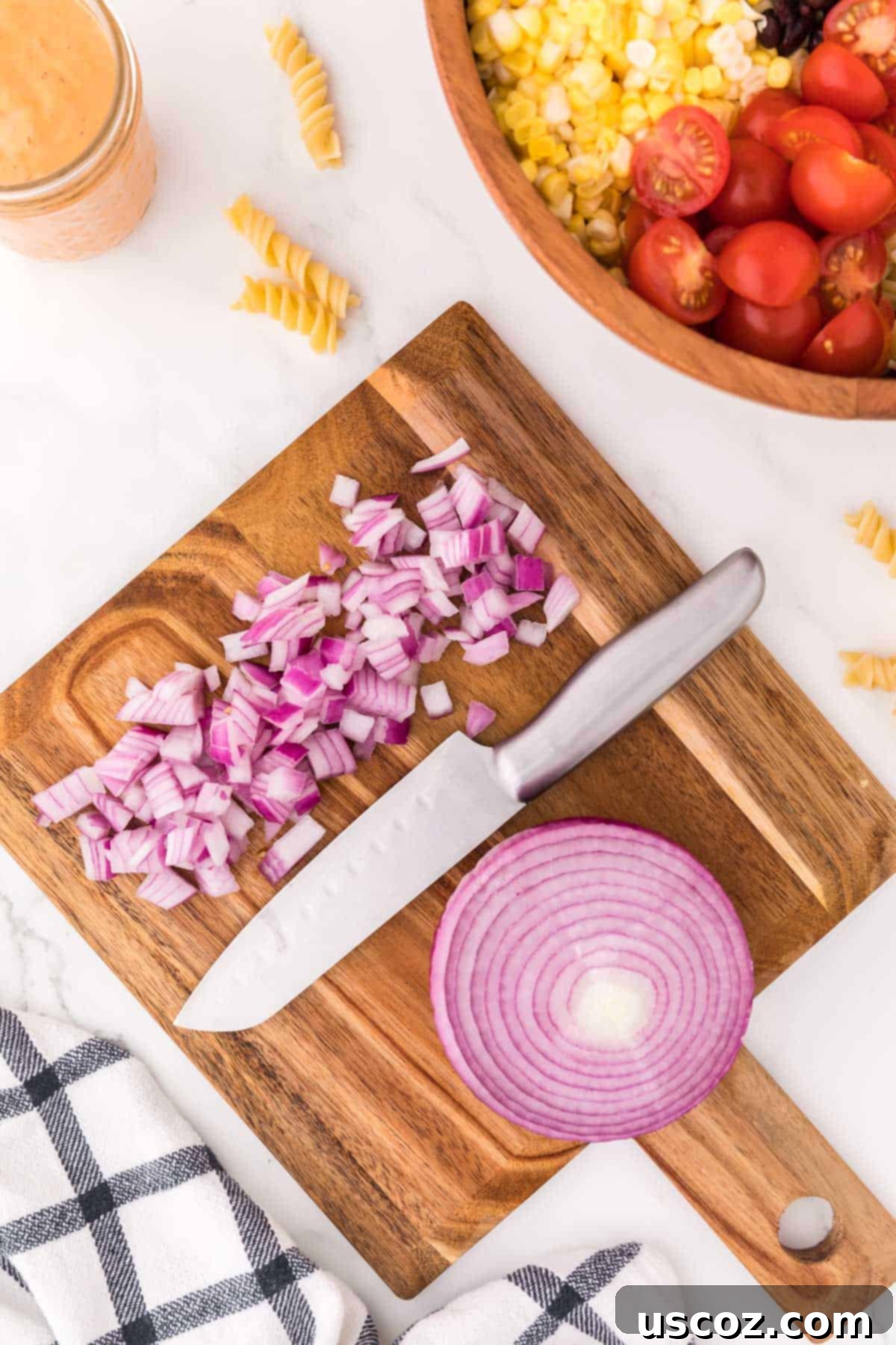 Zesty Southwest Pasta Delight 7 Finely chopped red onions on a cutting board, adding a pungent kick to the salad.