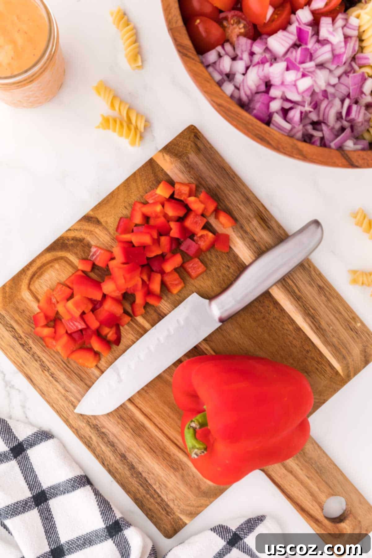 Zesty Southwest Pasta Delight 8 Diced red bell pepper on a cutting board, ready to add sweetness and crunch.