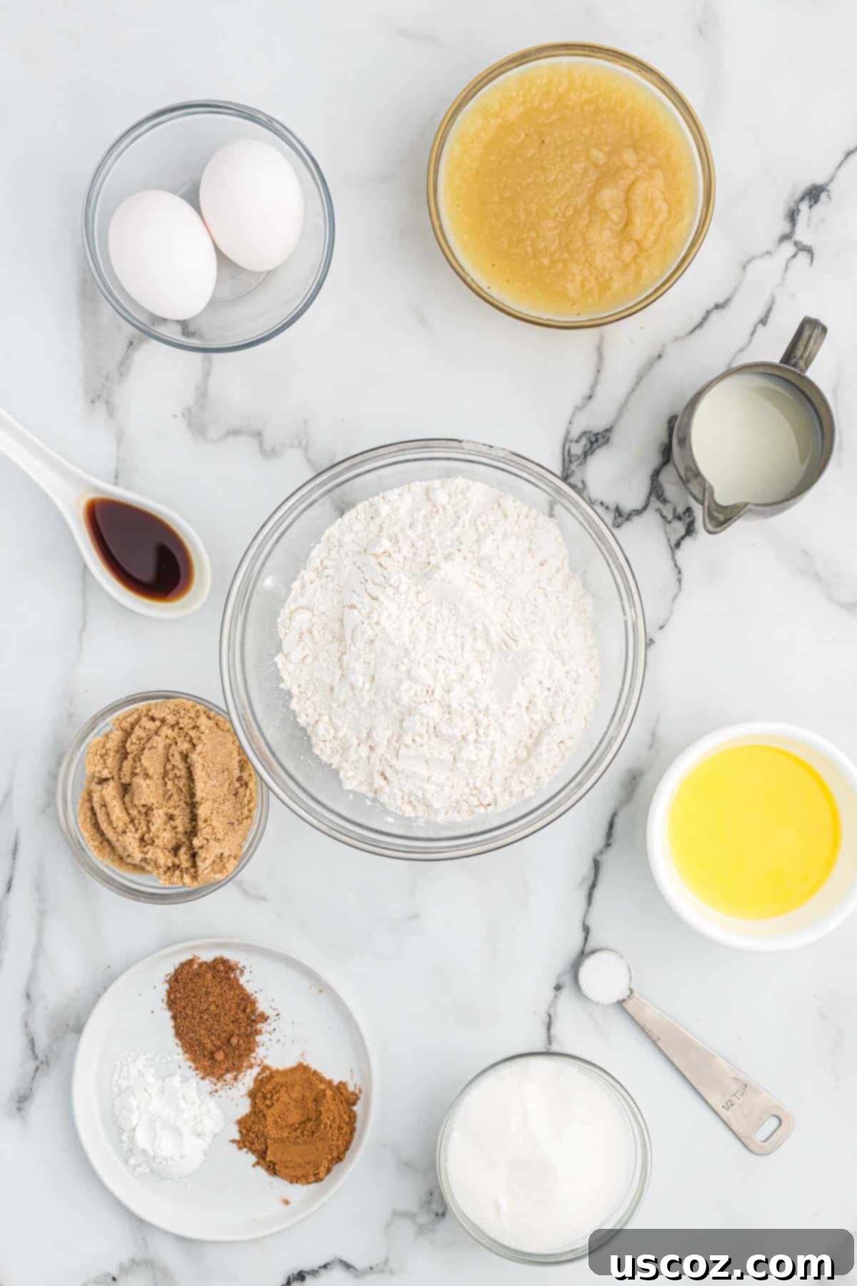 Homestyle Applesauce Muffins 4 All the necessary ingredients for baking applesauce muffins, neatly laid out on a kitchen counter, ready for preparation.