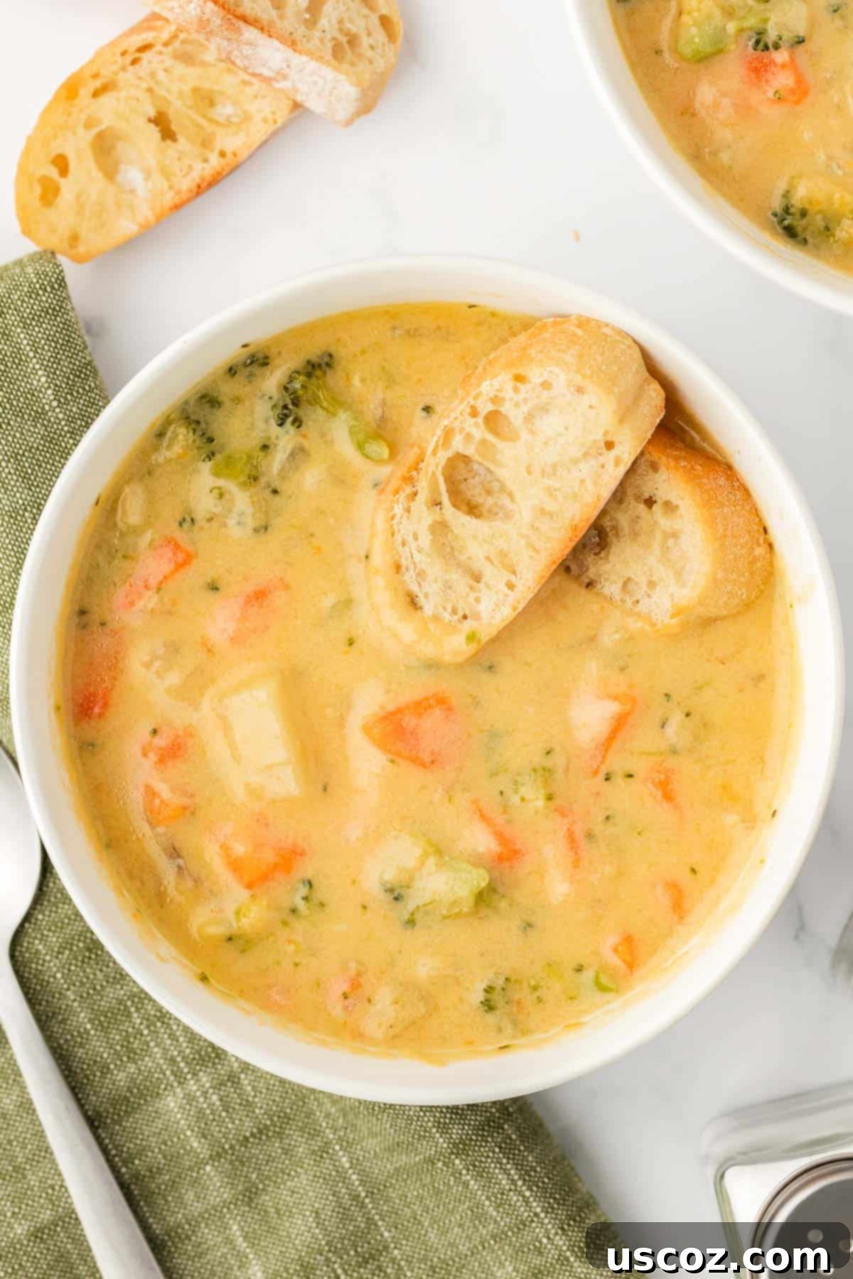Velvet Veggie Delight 2 A bowl of creamy vegetable soup garnished with fresh herbs and served with baguette slices, highlighting its comforting appeal.