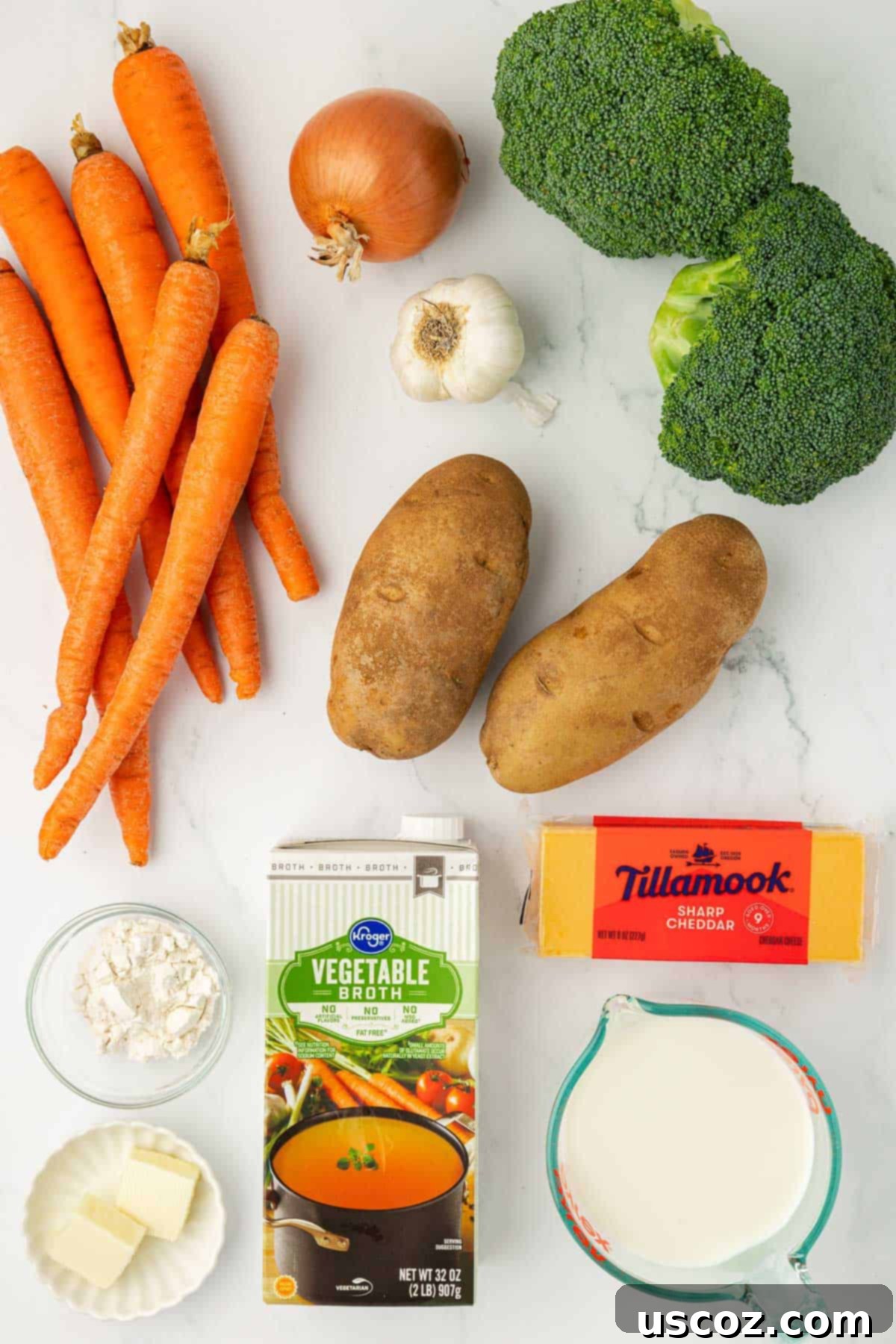 Velvet Veggie Delight 3 A vibrant selection of fresh ingredients laid out, including carrots, onion, garlic, broccoli florets, russet potatoes, butter, flour, vegetable broth, and sharp cheddar cheese, ready for making creamy vegetable soup.