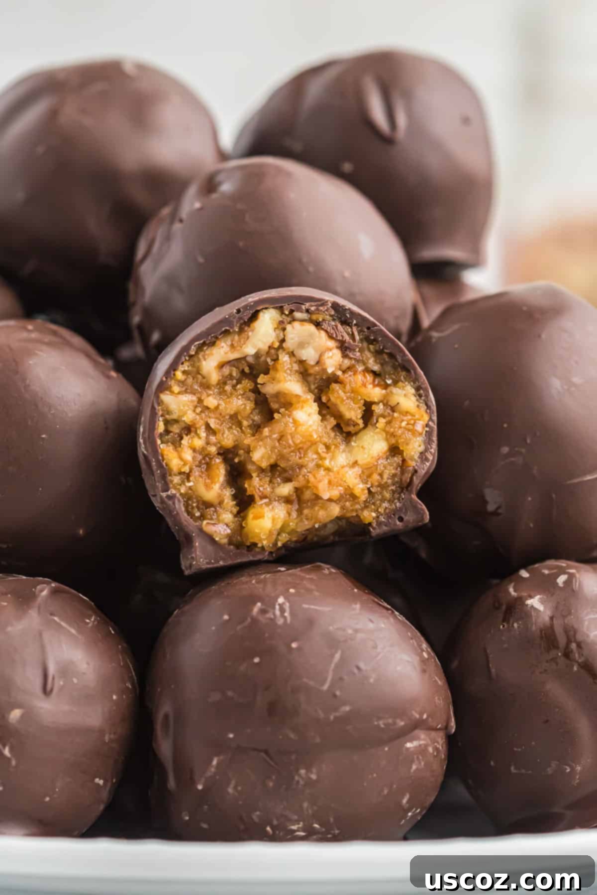 Pecan Pie Truffles 2 pecan pie ball with a bite taken out, showing the gooey filling