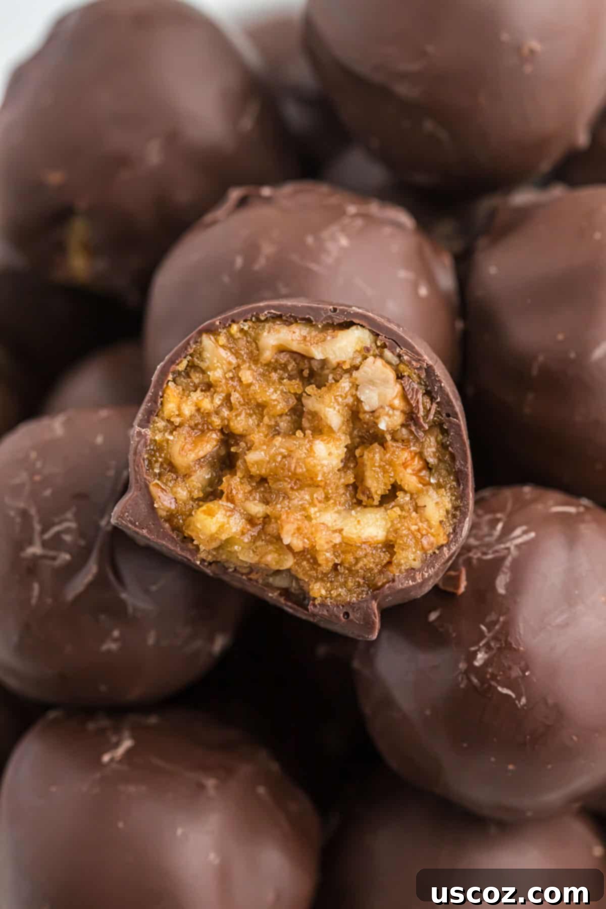 Pecan Pie Truffles 12 a pecan pie ball with a bite taken out, resting on a white surface