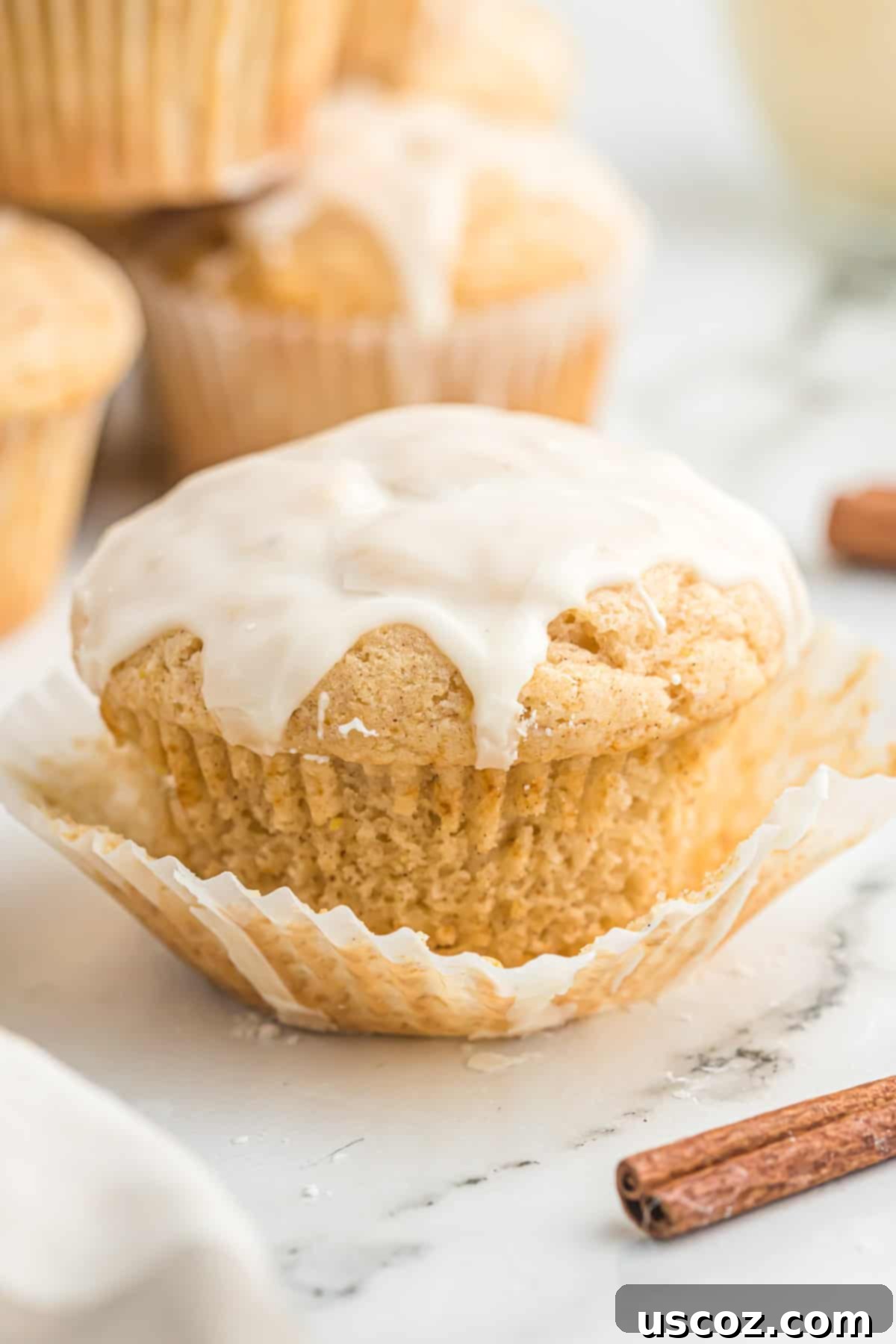 Holiday Eggnog Muffins 12 A beautifully glazed eggnog muffin on a plate, garnished with a sprinkle of fresh nutmeg, ready to be enjoyed.