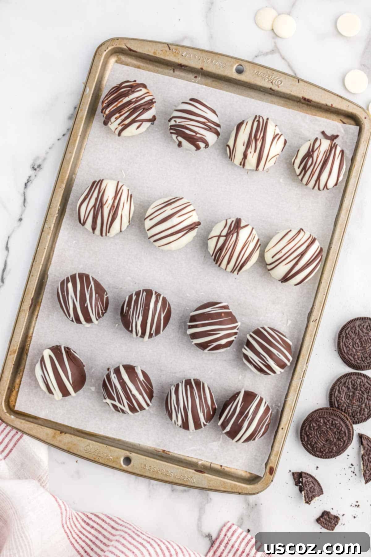 Oreo Truffles 11 Artfully decorated Oreo balls, featuring contrasting chocolate drizzles, arranged on a baking sheet, showcasing their festive potential.
