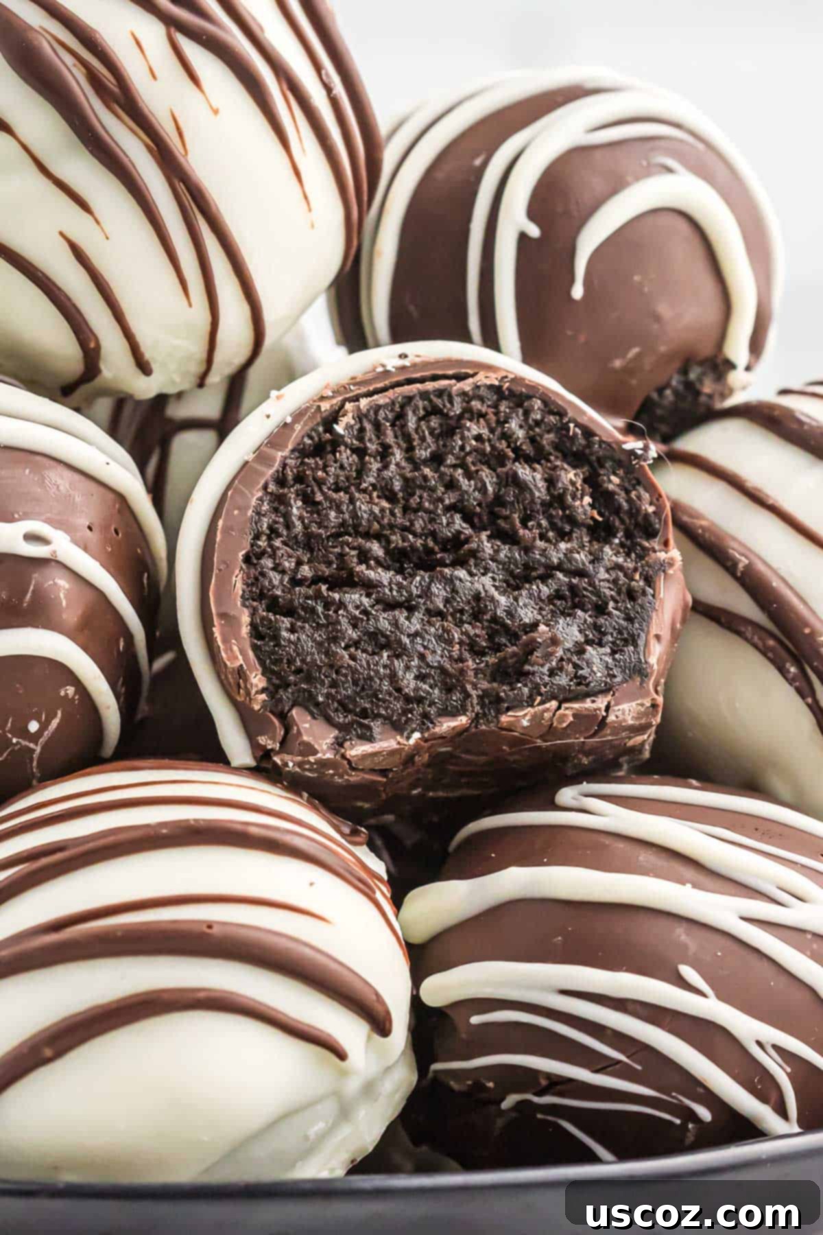 Oreo Truffles 14 A close-up image of an Oreo truffle with a bite taken out, revealing its rich, dark, and creamy interior and crisp chocolate coating.