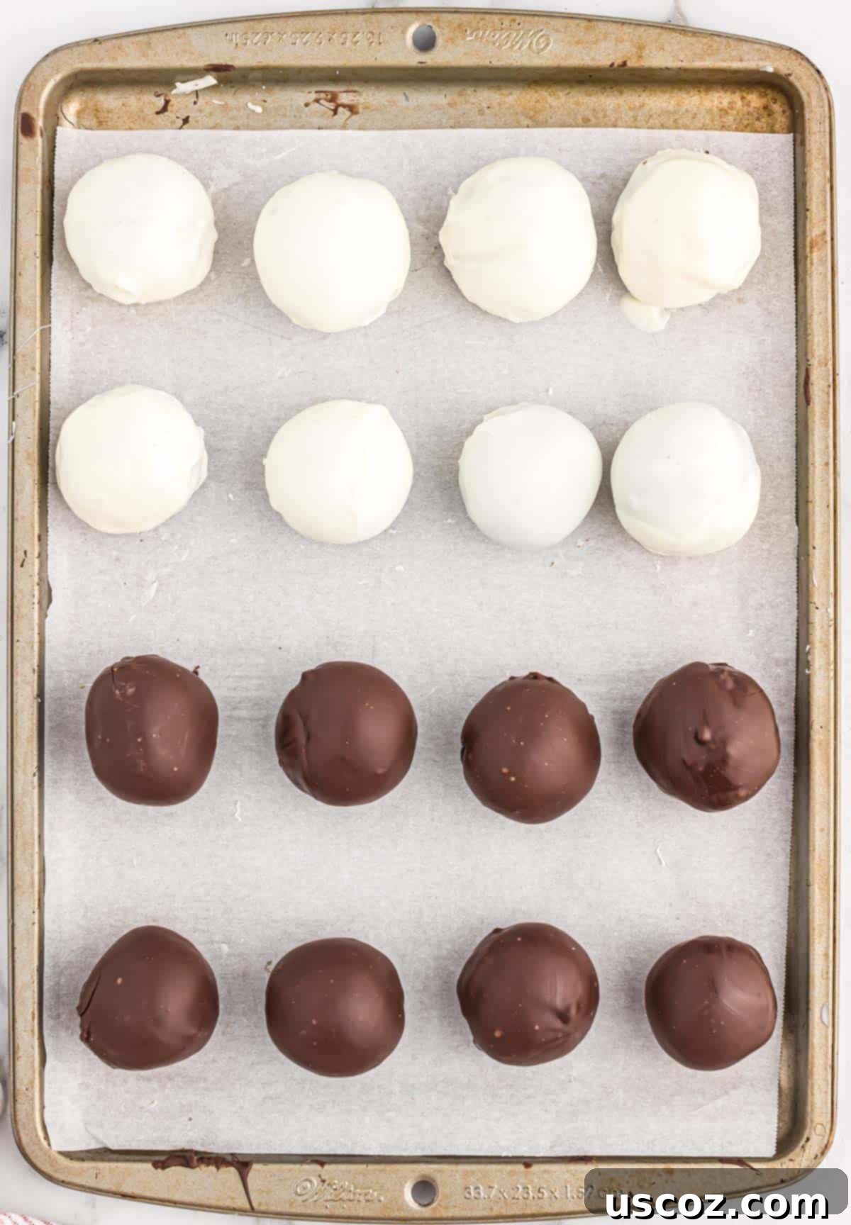 Oreo Truffles 10 Both dark and white chocolate-dipped Oreo balls neatly arranged on a parchment-lined baking sheet, firming up in the refrigerator.