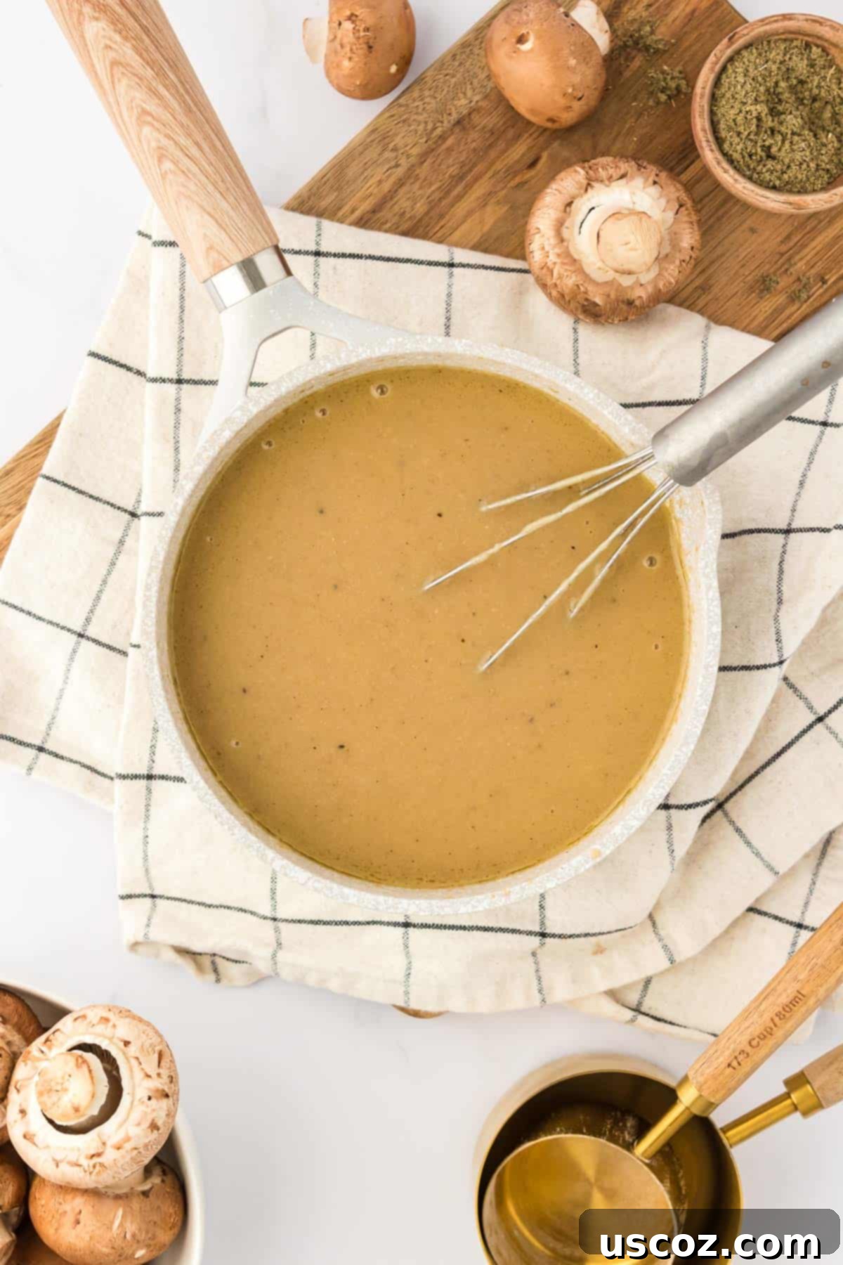 Perfect Vegetarian Gravy 20 A whisk stirring a luscious vegetarian gravy in a stainless steel saucepan, showing its smooth texture.