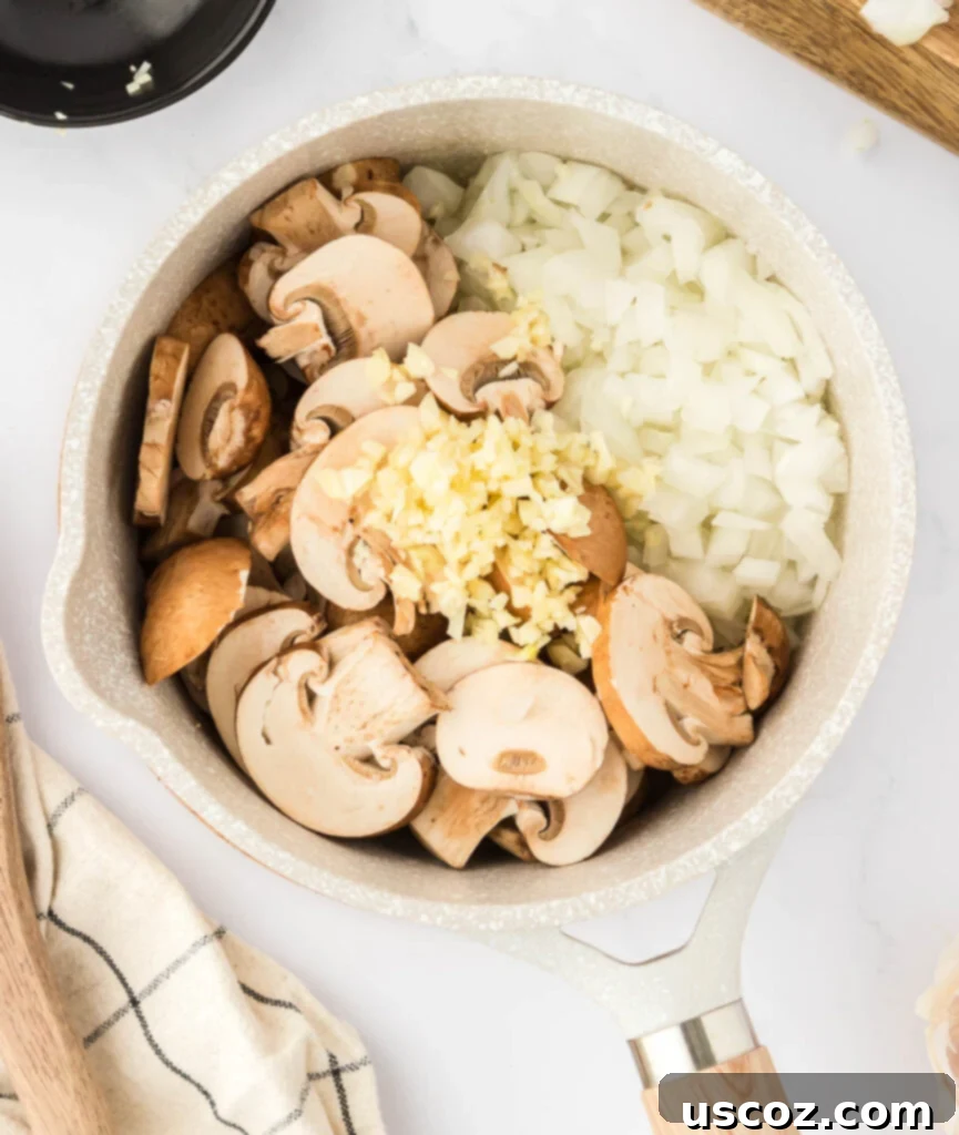 Perfect Vegetarian Gravy 7 Raw sliced mushrooms, diced onions, and minced garlic starting to sauté in a saucepan with melted butter.