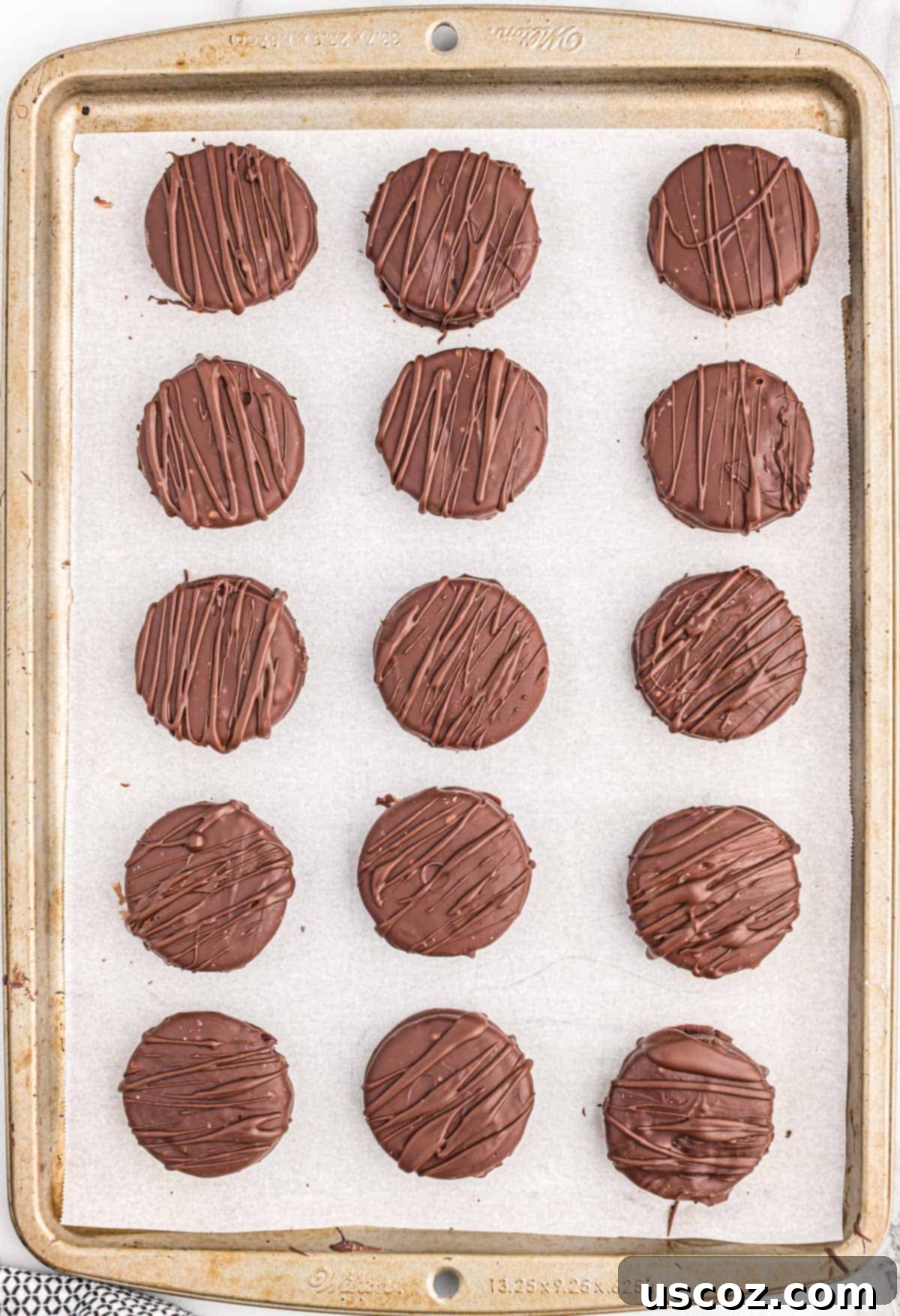 Decadent Chocolate Dipped Oreos 7 chocolate drizzled oreos on a baking sheet