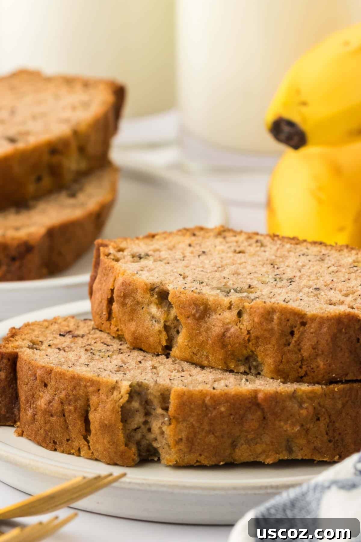 Ultimate Moist Banana Bread 2 Two perfect slices of golden brown homemade banana bread, ready to be enjoyed.