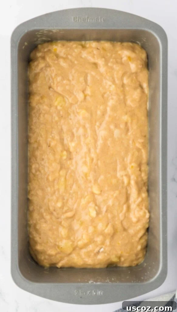 Ultimate Moist Banana Bread 13 Classic banana bread batter poured into a greased loaf pan, ready for baking.