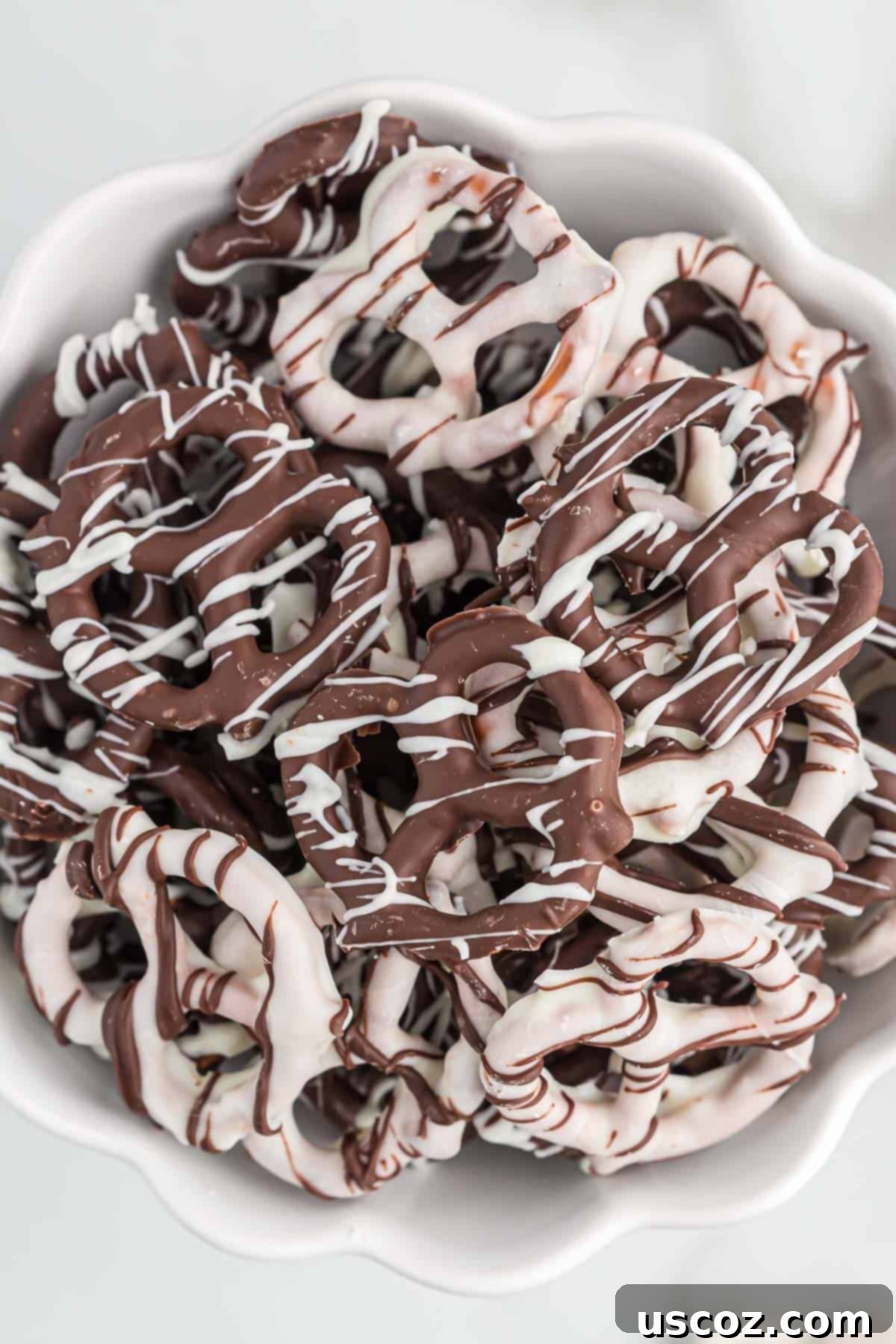 Chocolate Pretzel Perfection 12 A collection of beautifully drizzled chocolate covered pretzels on a platter, ready to be served.