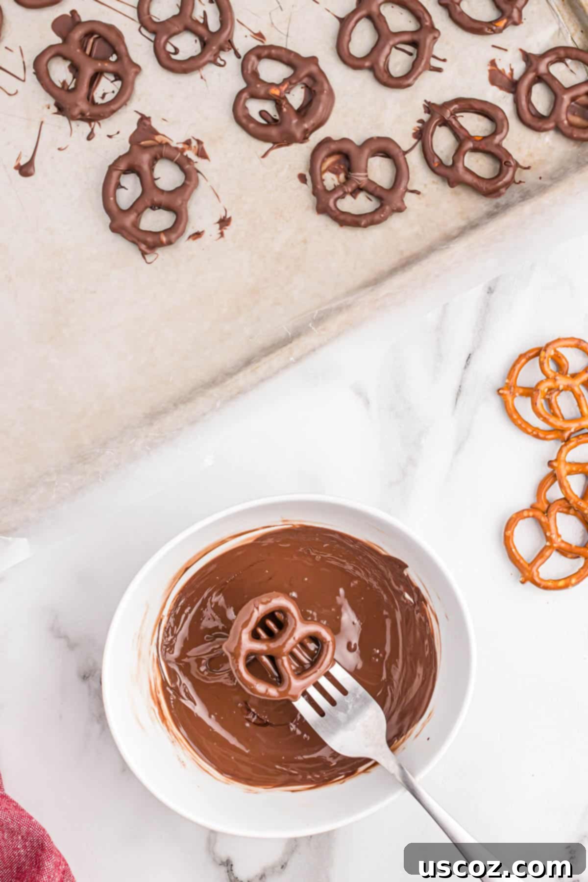 Chocolate Pretzel Perfection 6 A mini pretzel fully dipped in melted dark chocolate, with excess gently tapped off, resting on the side of the bowl.