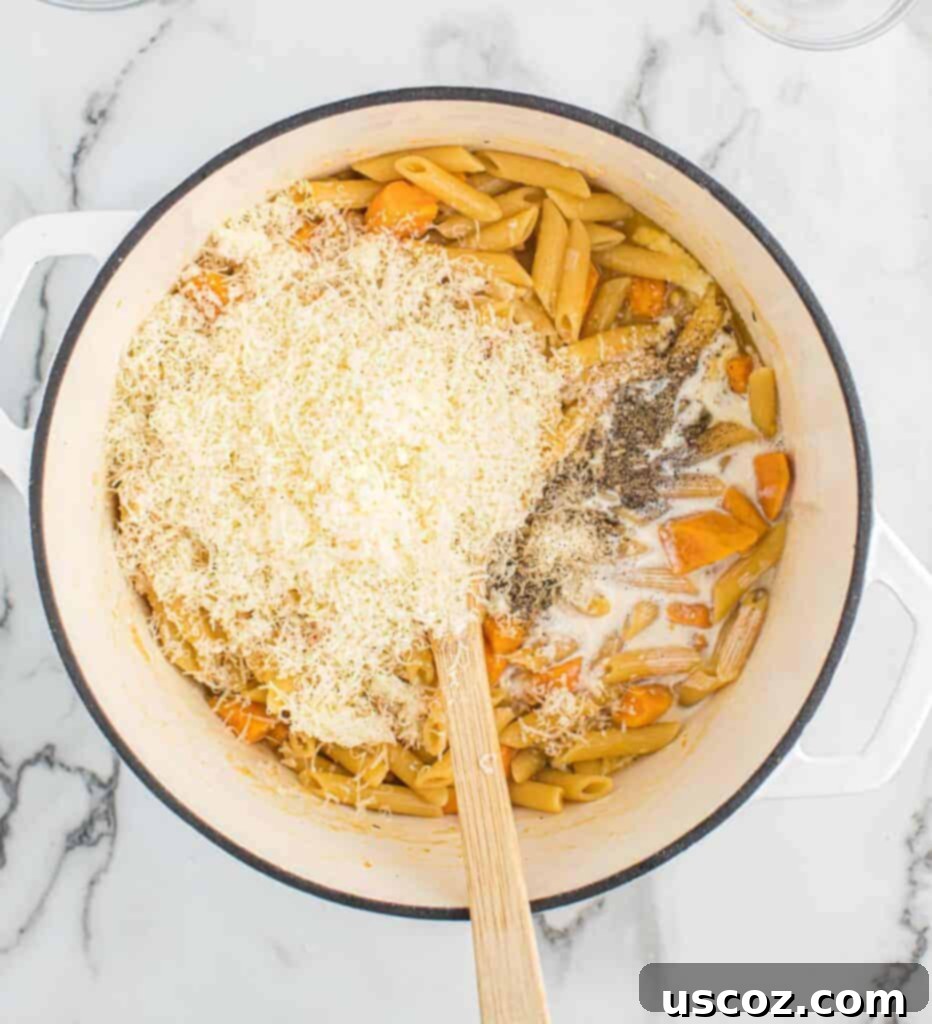 Golden Sweet Potato Strands 7 adding grated parmesan cheese to the creamy pasta